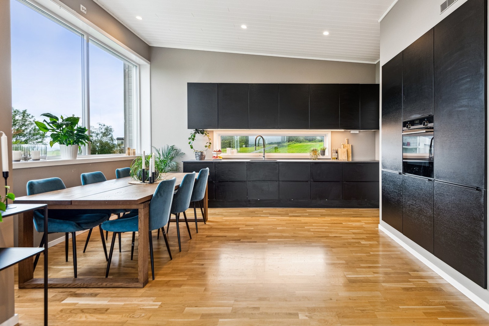 Moderne kjøkken med vinduer på 3 sider. Her har man masse naturlig lys inn og har nydelig utsikt utover bygda og mot Trondheimsfjorden. Foto: EFKT (Hamish Grey) Galleribilde