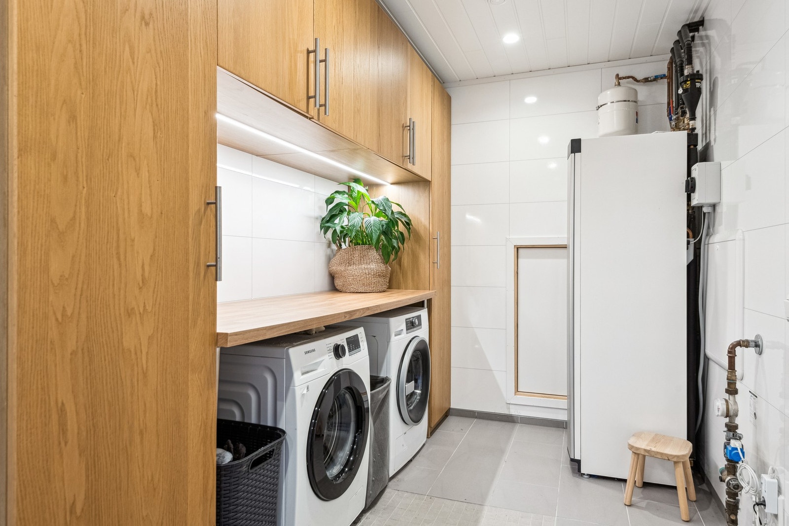 Vaskerom med avsatt plass til vaskemaskin og tørketrommel. God plass til lagring i innredning, samt i kott bak varmepumpa. Galleribilde