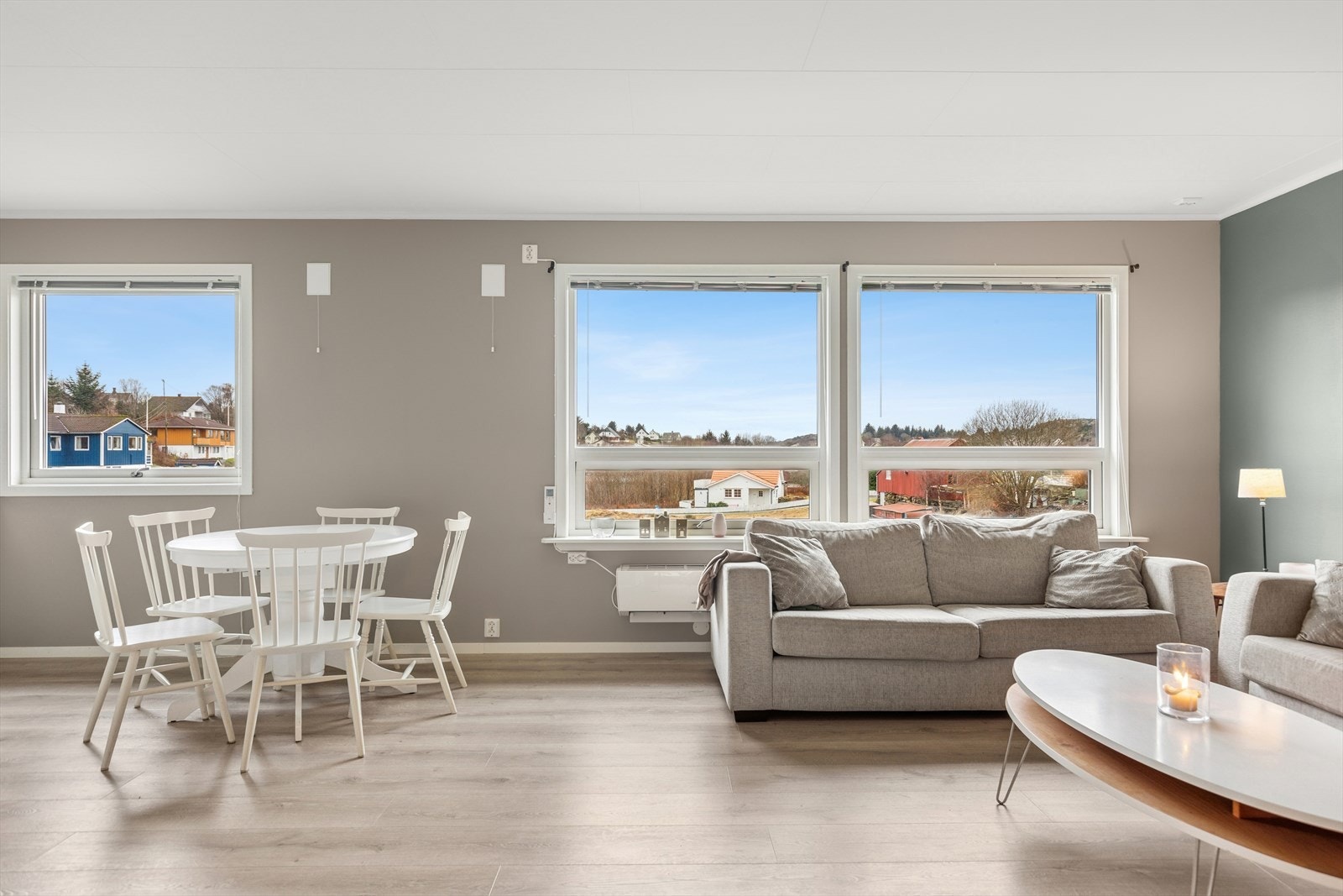 Stuen har store vinduer som slipper inn rikelig med naturlig lys, noe som gir rommet en lys og luftig atmosfære. Galleribilde