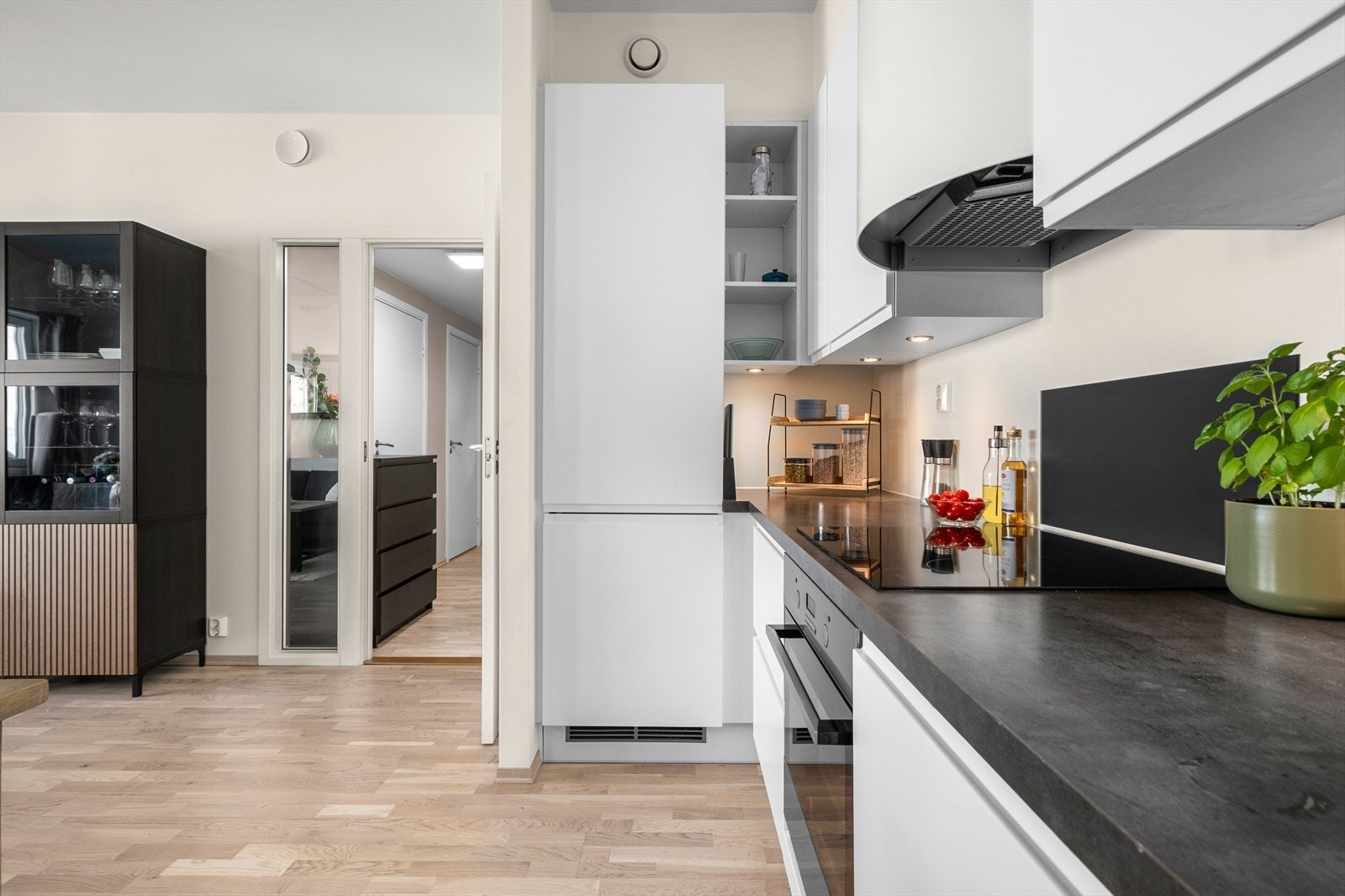 Arealet er godt utnyttet da kombi-kjøleskapet er plassert ved innhuket, noe som gir ekstra skap og benkeplass. Integrerte hvitevarer på kjøkken medfølger naturligvis handelen. Galleribilde