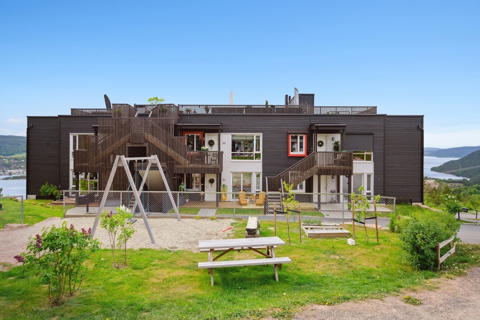 Pent opparbeidede fellesarealer med gressplen, lekearealer og beplantning. Galleribilde