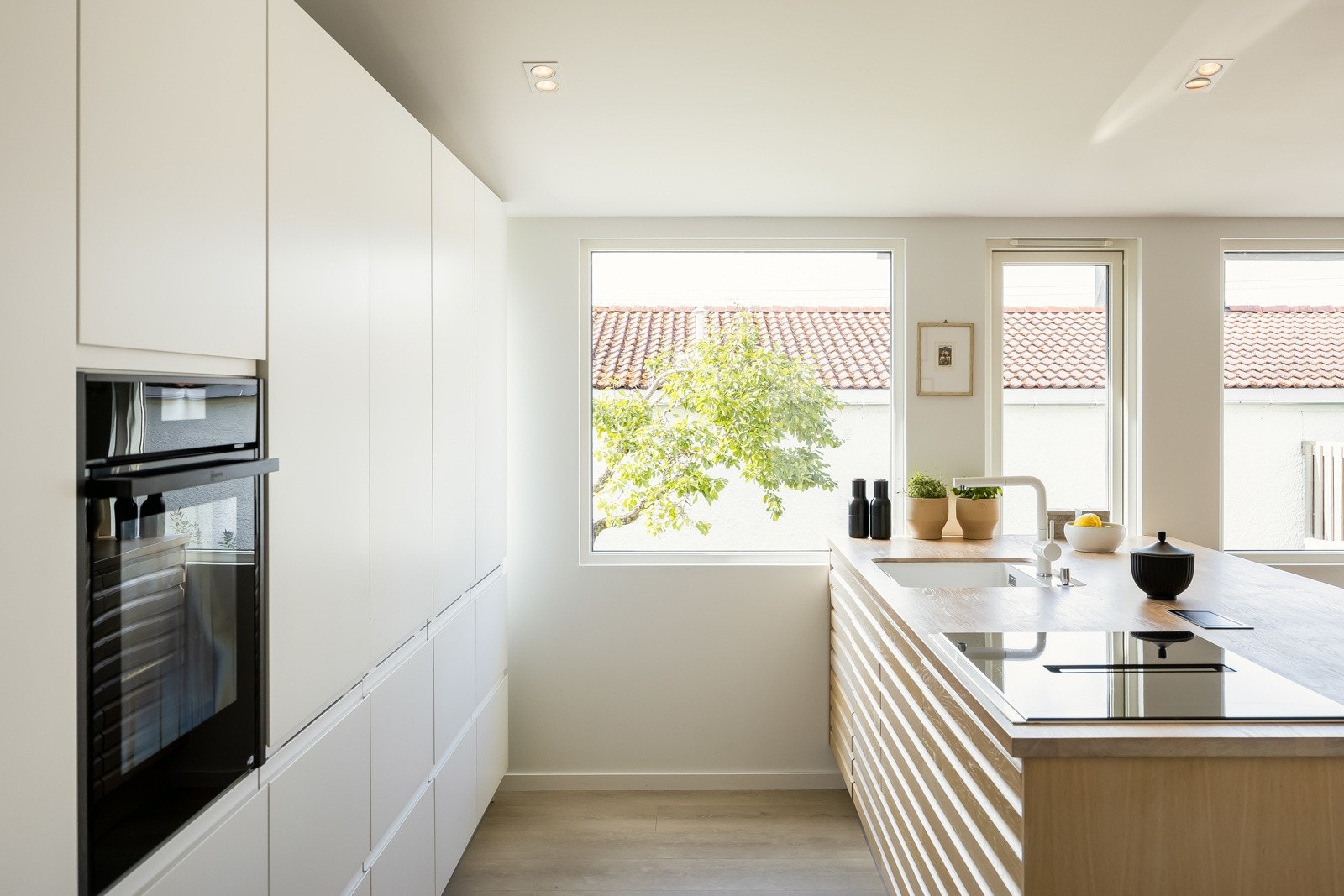 Velutstyrt med integrert kjøleskap og fryseskap i full størrelse, oppvaskamskin, induksjonstopp og komfyr med pyrolyse. Galleribilde