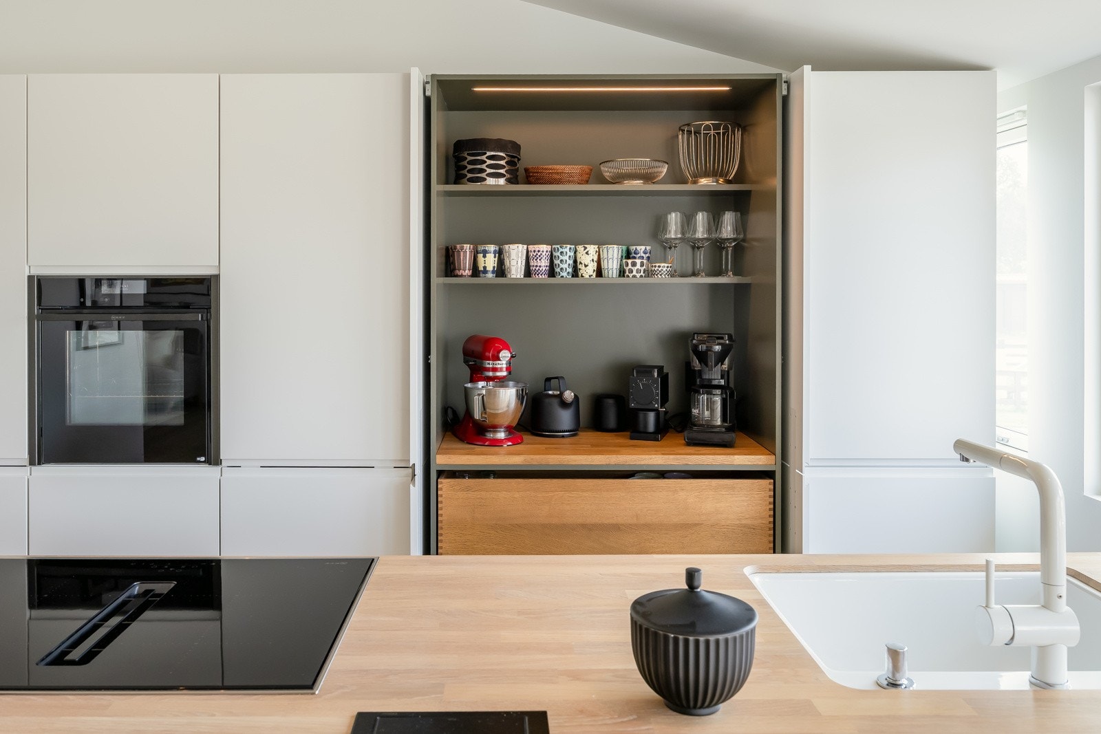 Sømløs utførelse med underlimt vask, integrert ventilator og pop-up med dobbel stikkontakt. Galleribilde