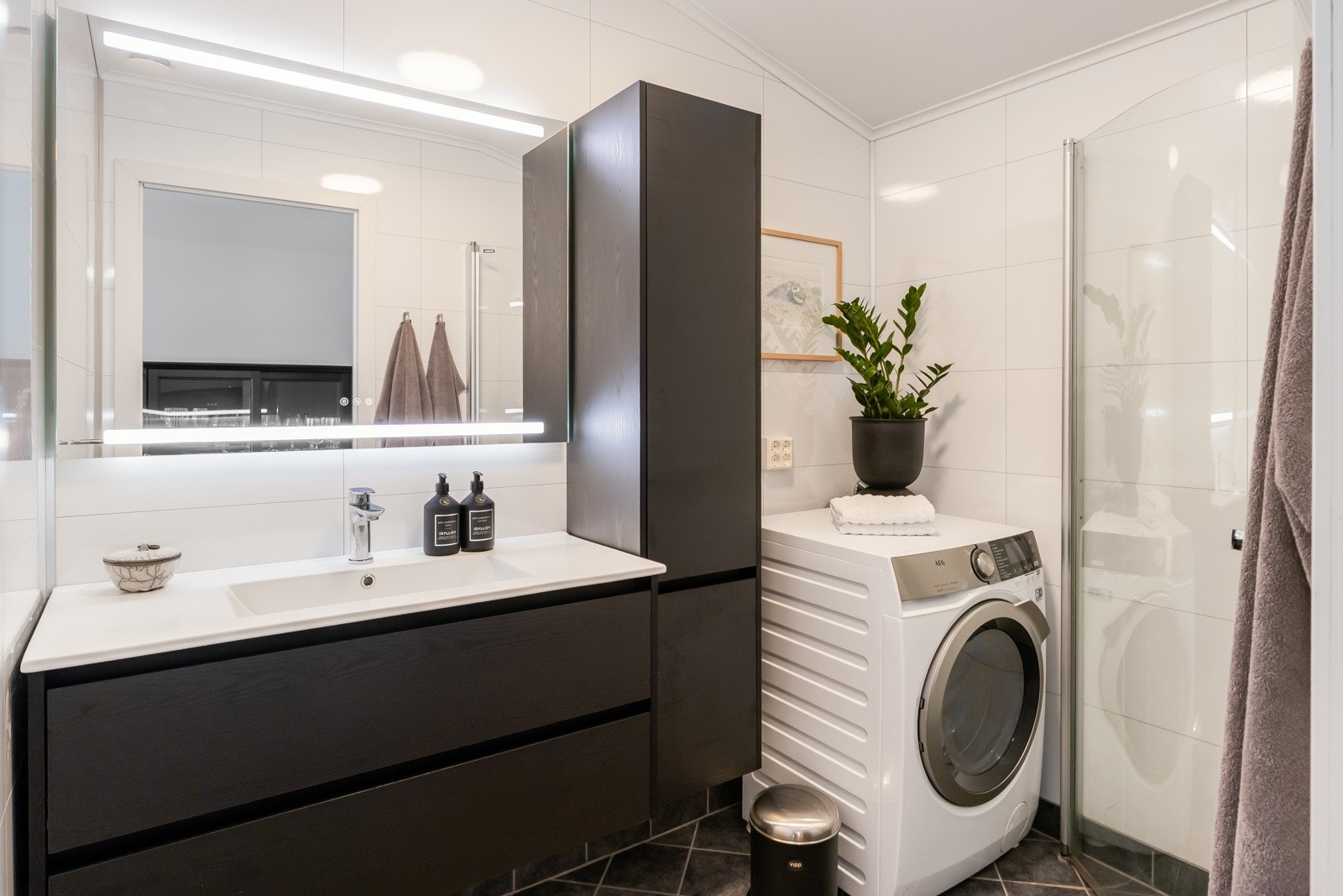 Flislagt bad fra 2017 med dusjhjørne med innfellbare dører, opplegg for vaskemaskin og gulvvarme. Ny baderomsinnredning i 2025 fra Korsbakken Bad AS i mørkbeiset eik. Galleribilde