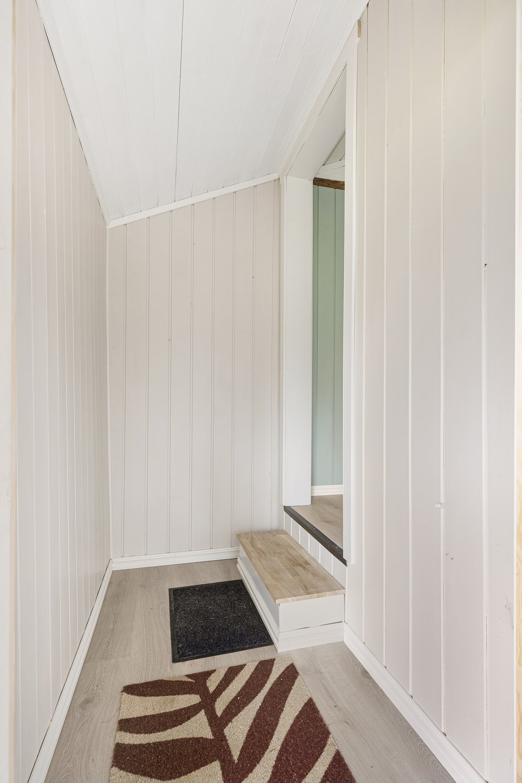 Lys gang med en liten trapp inn til stuen. Galleribilde