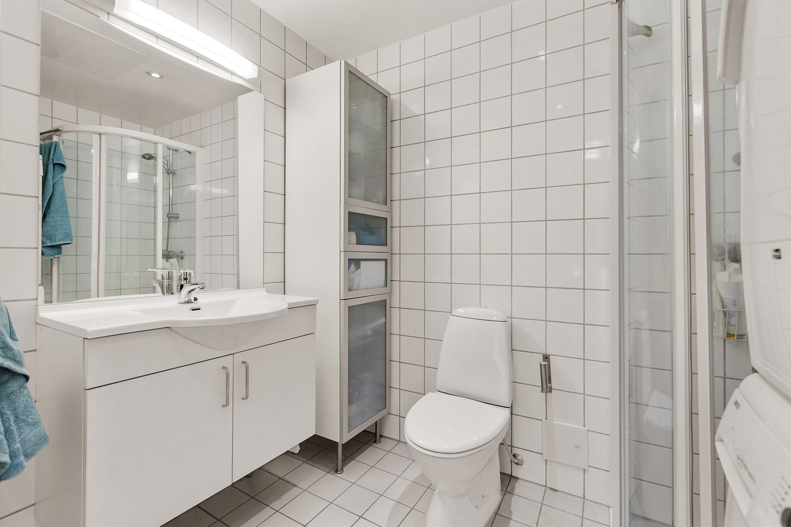 Stilrent bad fra byggeår med innredning fra HTH, lyse fliser og varmekabler i gulv. Galleribilde