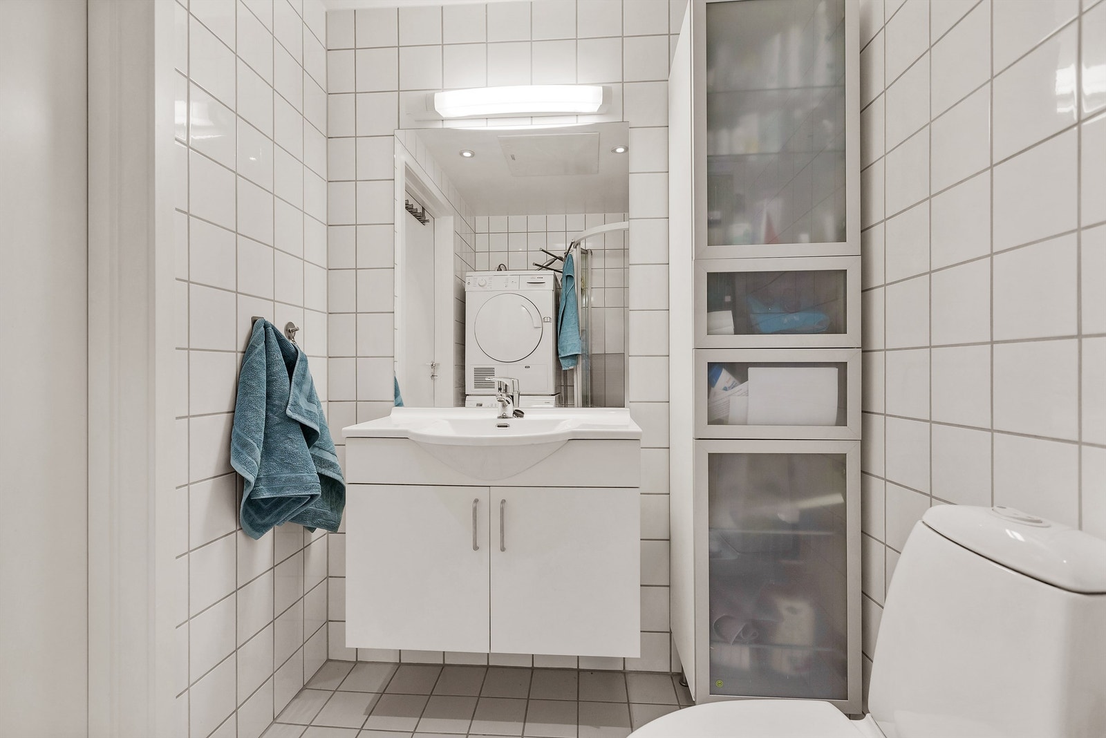 Badet er innredet med vegghengt servantskap, speil med overlys, dusjkabinett, stående toalett i tillegg til opplegg for vaskemaskin. Galleribilde