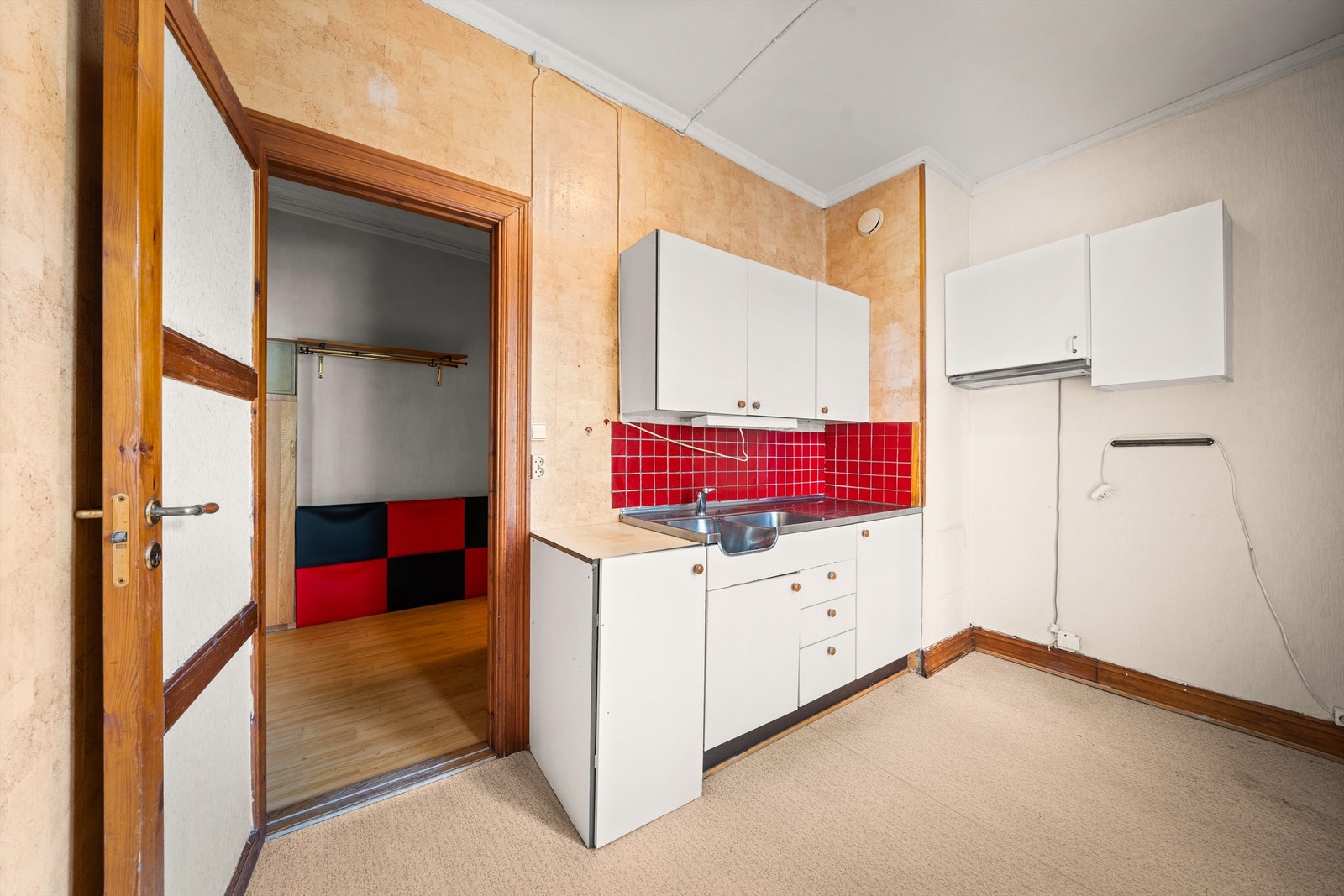 Eldre kjøkken med lyse, glatte fronter, laminat benkeplater, fliser over benk, rustfri oppvaskkum og ventilator med filter. Galleribilde