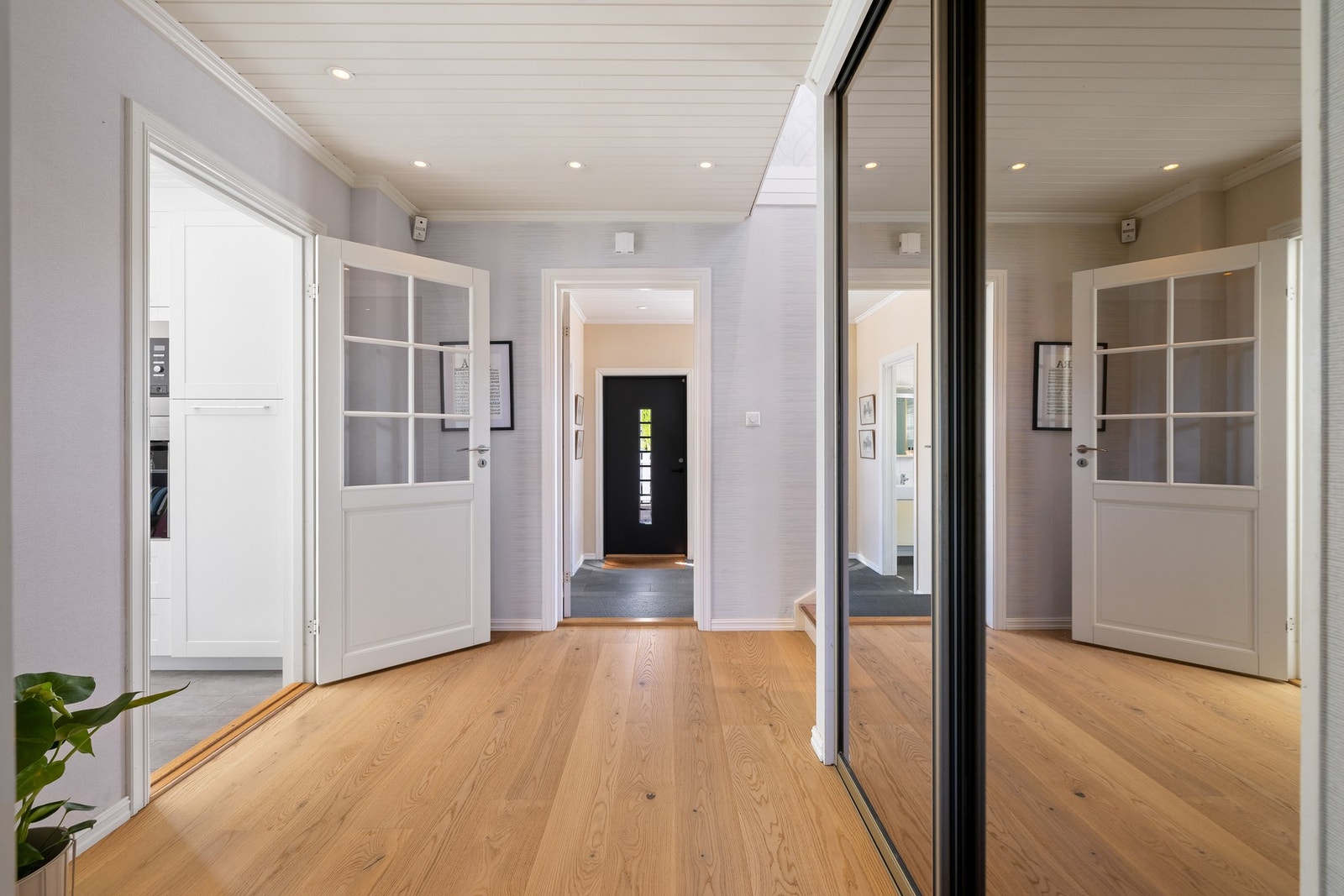 Yttertøy, sko og utstyr ryddes enkelt bort i en takhøy, plassbygd skyvedørsgarderobe. Galleribilde