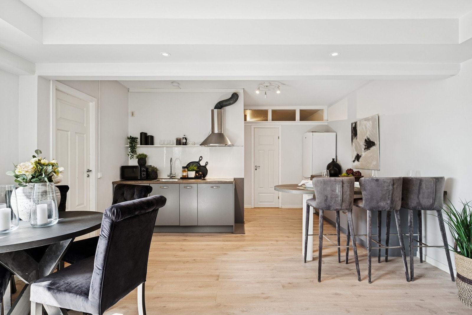 Du kommer inn til en moderne, åpen løsning mellom stue og kjøkken. Galleribilde