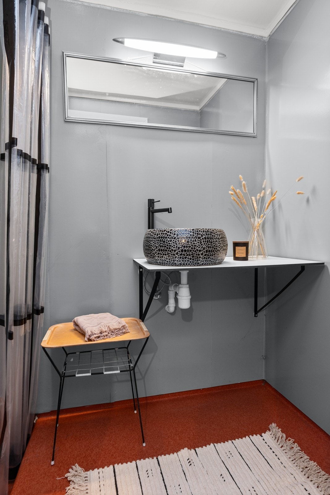 Bad i underetasje med servant og dusj på gulv. Det er også et eget separat toalettrom i samme etasje. Galleribilde