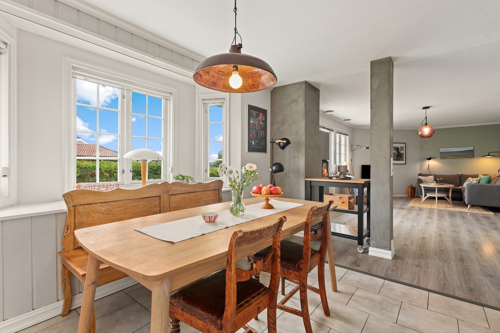 Åpen løsning med peisovnen som naturlig skille mellom kjøkken og stue. Galleribilde