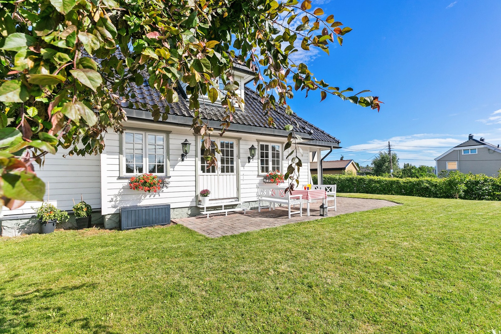 Solrik, vestvendt uteplass med inngang til stua i leilighet A. Galleribilde