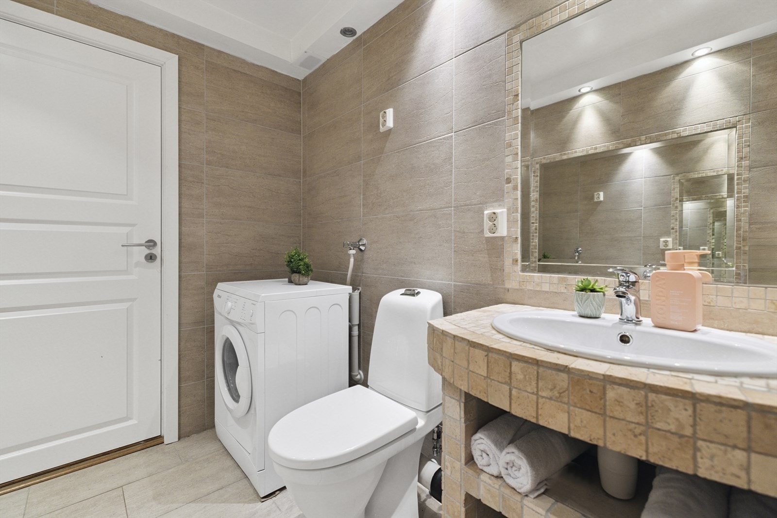 Smart utnyttelse av plassen under vasken gir enkel oppbevaring av håndklær. Galleribilde