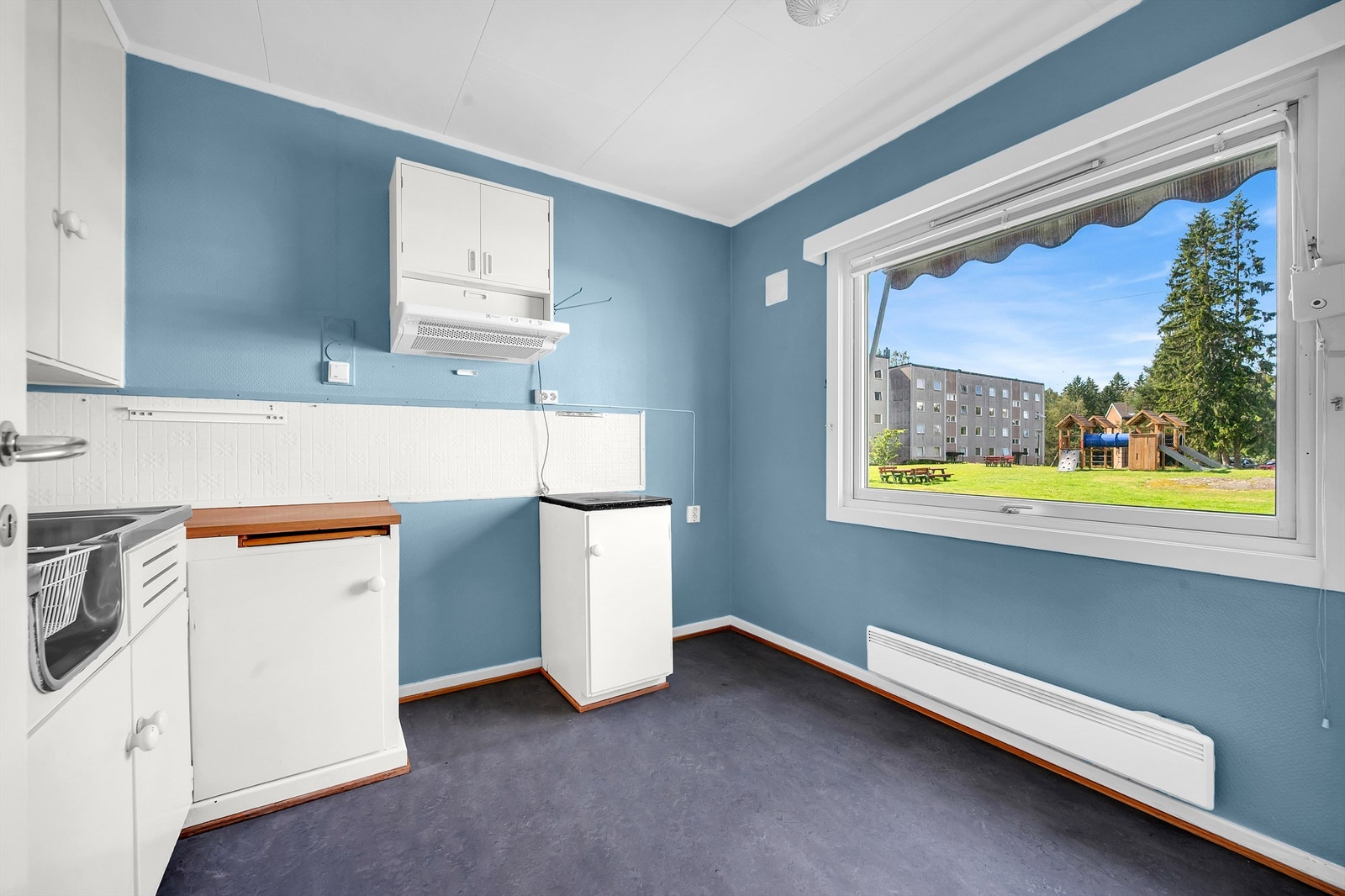 Kjøkken med stort vindu som gir rikelig med naturlig lys. Galleribilde