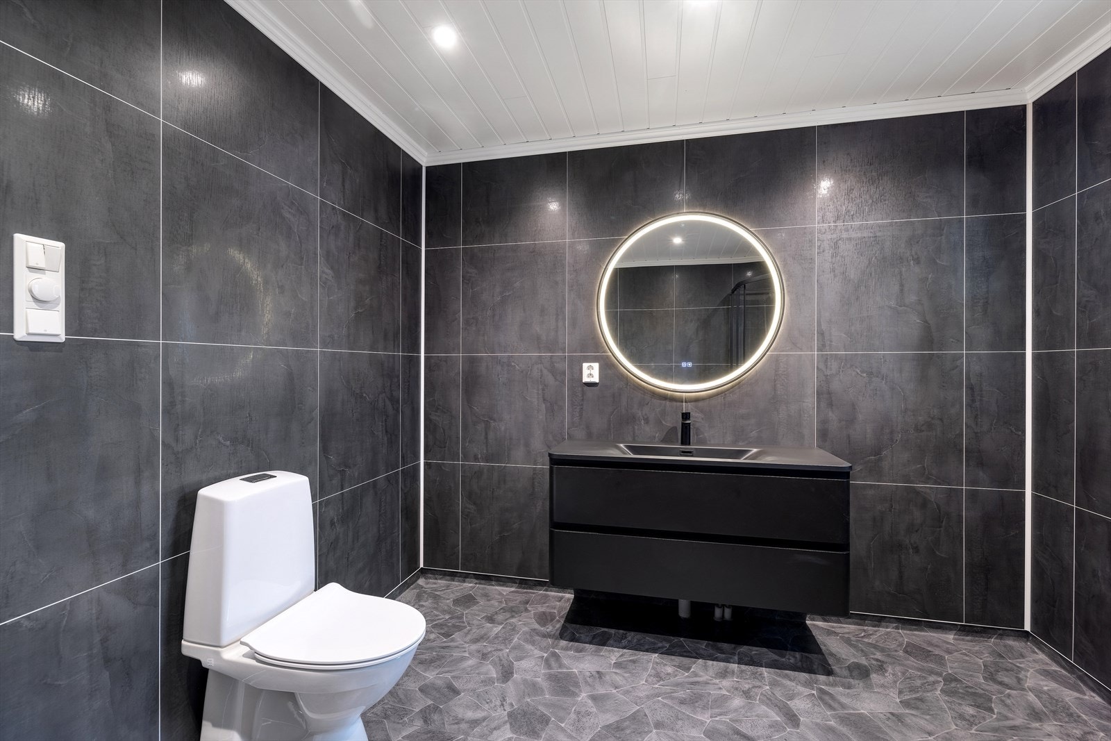 Rommet er innredet med innredning med nedfelt servant, speil med integrert belysning, toalett og dusjkabinett. Galleribilde