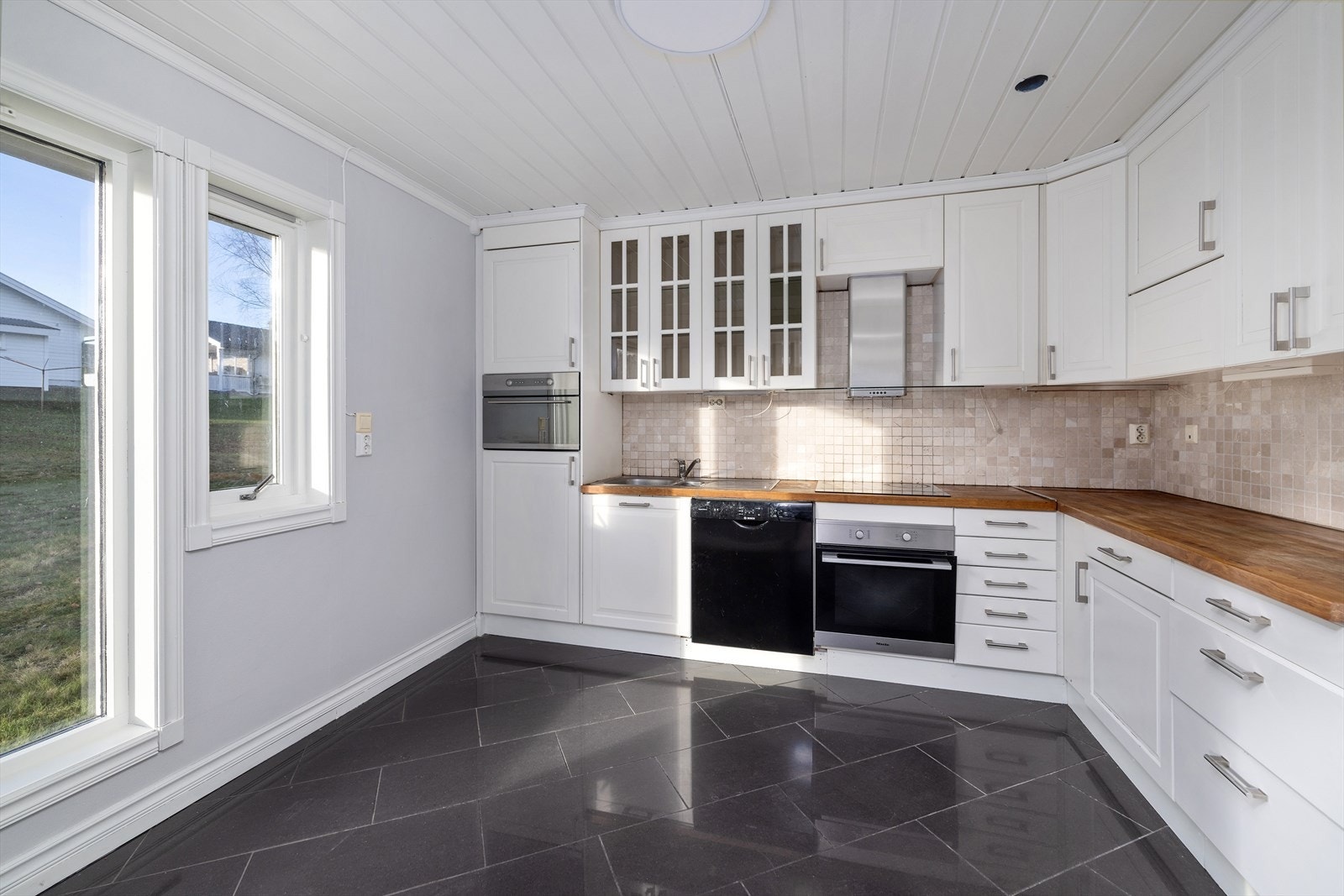 Kjøkkenet har innredning med profilerte fronter, hvor deler av overskapene er med vitrinedører. Galleribilde