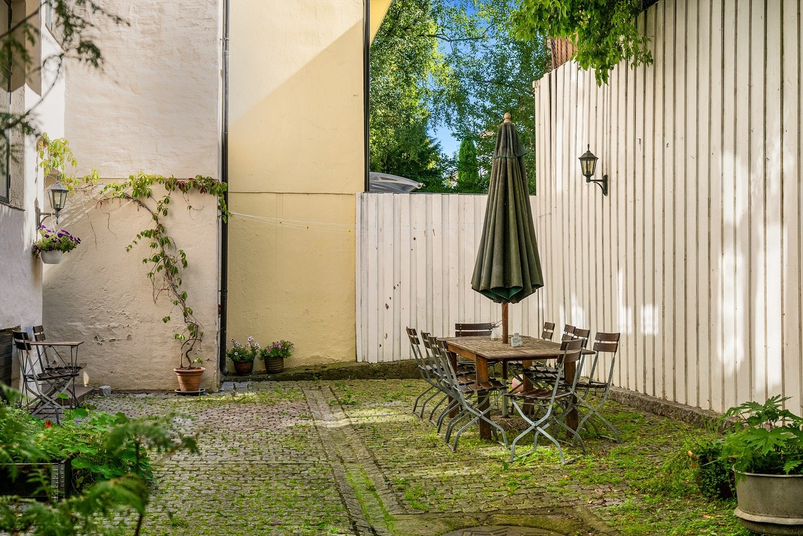 Hyggelig uteområde med forskjellige sittegrupper og beplantning. Galleribilde