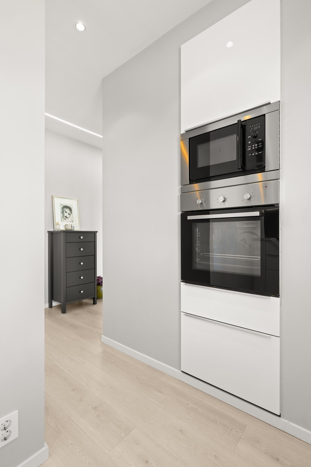 Kjøkkenet har integrerte hvitevarer som kjøl/fryseskap, mikrobølgeovn, stekeovn, platetopp og oppvaskmaskin Galleribilde