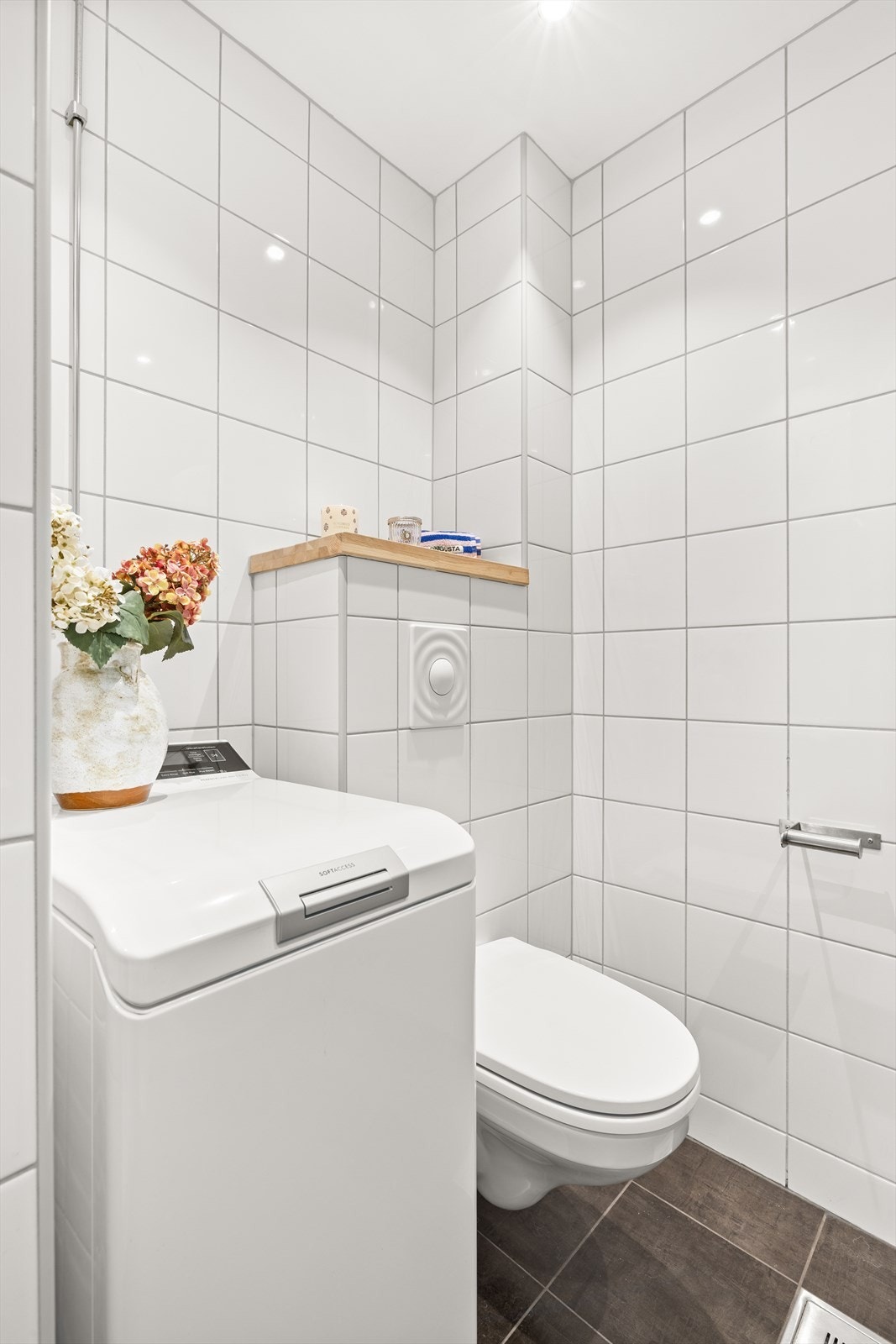 Badet har varmekabler i gulv, toalett, opplegg for vaskemaskin og servant med innredning Galleribilde