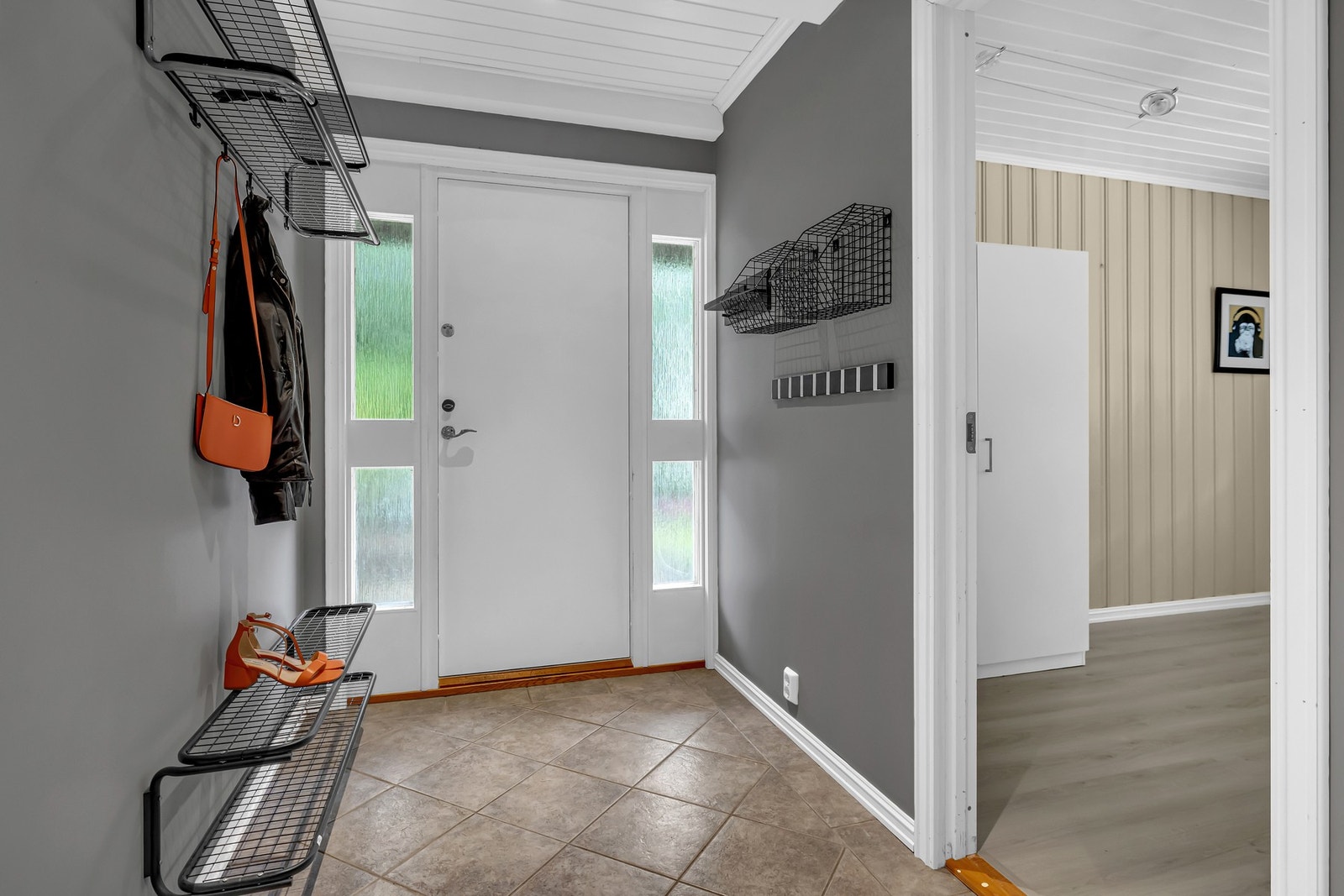 Ved ankomst til underetasjen møtes du av en romslig og praktisk entré med moderne fliser på gulvet - både stilrent og lettstelt. Galleribilde