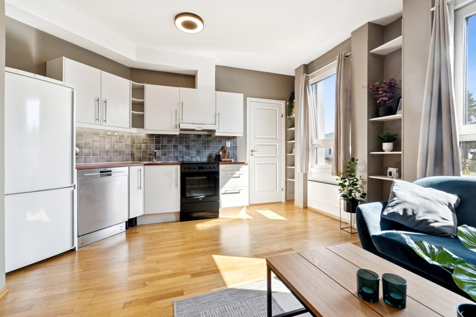 Kjøkkenet har hvite slette fronter med benkeplate i laminat. Galleribilde