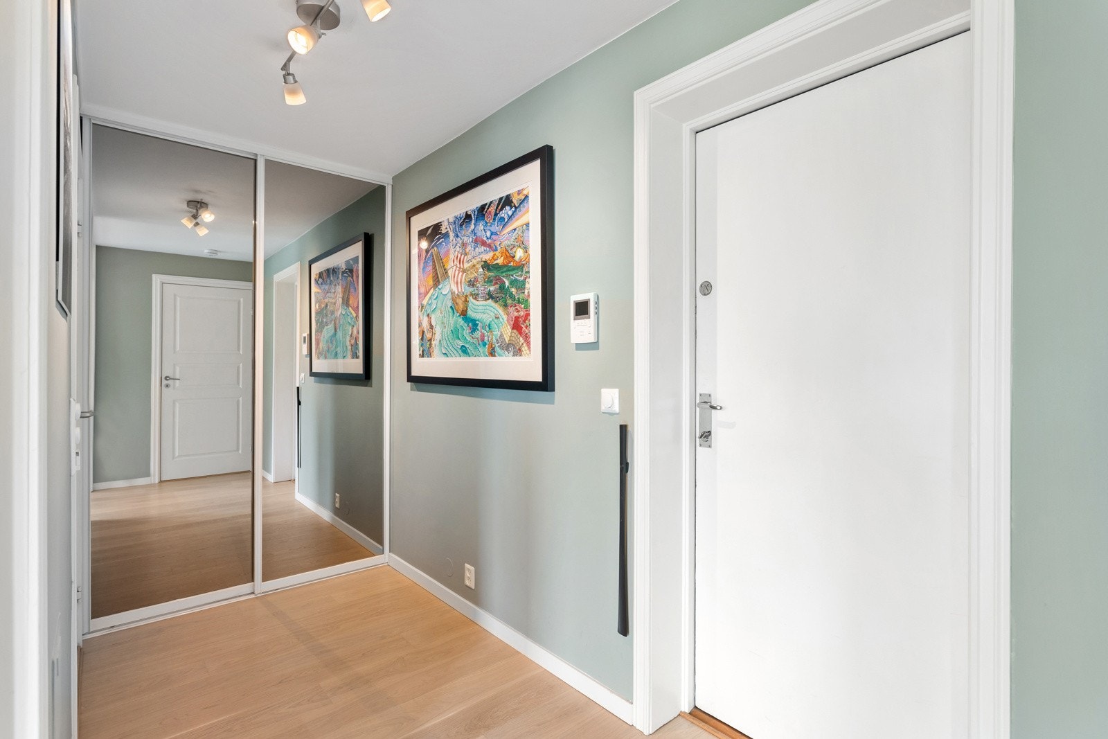 Innbydende entré med stor skuvedørsgarderobe med speilfronter. Galleribilde