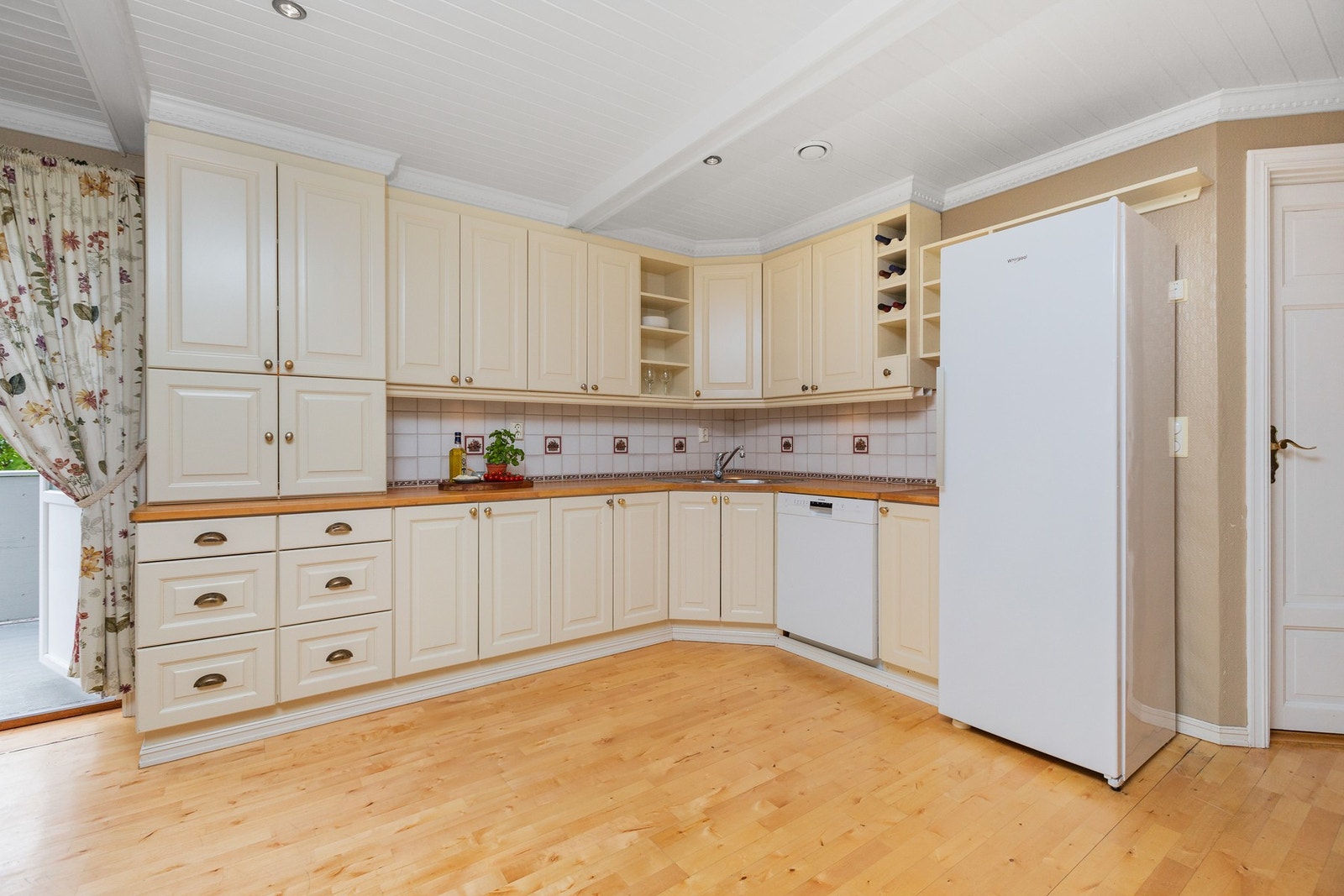 Kjøkken med god innredning og takhøye overskap Galleribilde