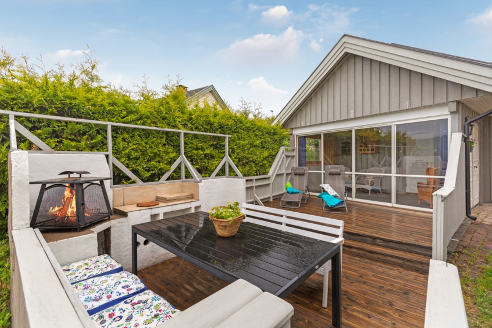 Felles uteplass med glassdør til overbygget del. Herfra er det videre tilgang til garasjebygget. Galleribilde