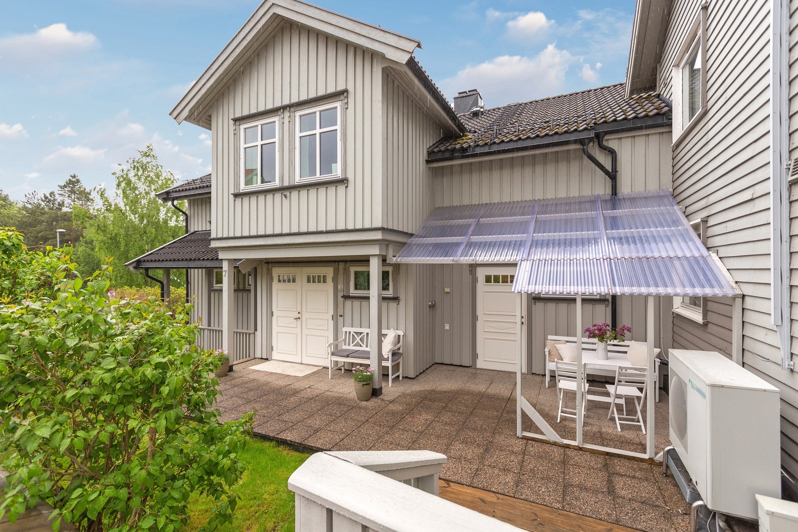 Inngangspartiet til eneboligen, dels overbygd med plasttak. Inngang også til vaskerom. Galleribilde