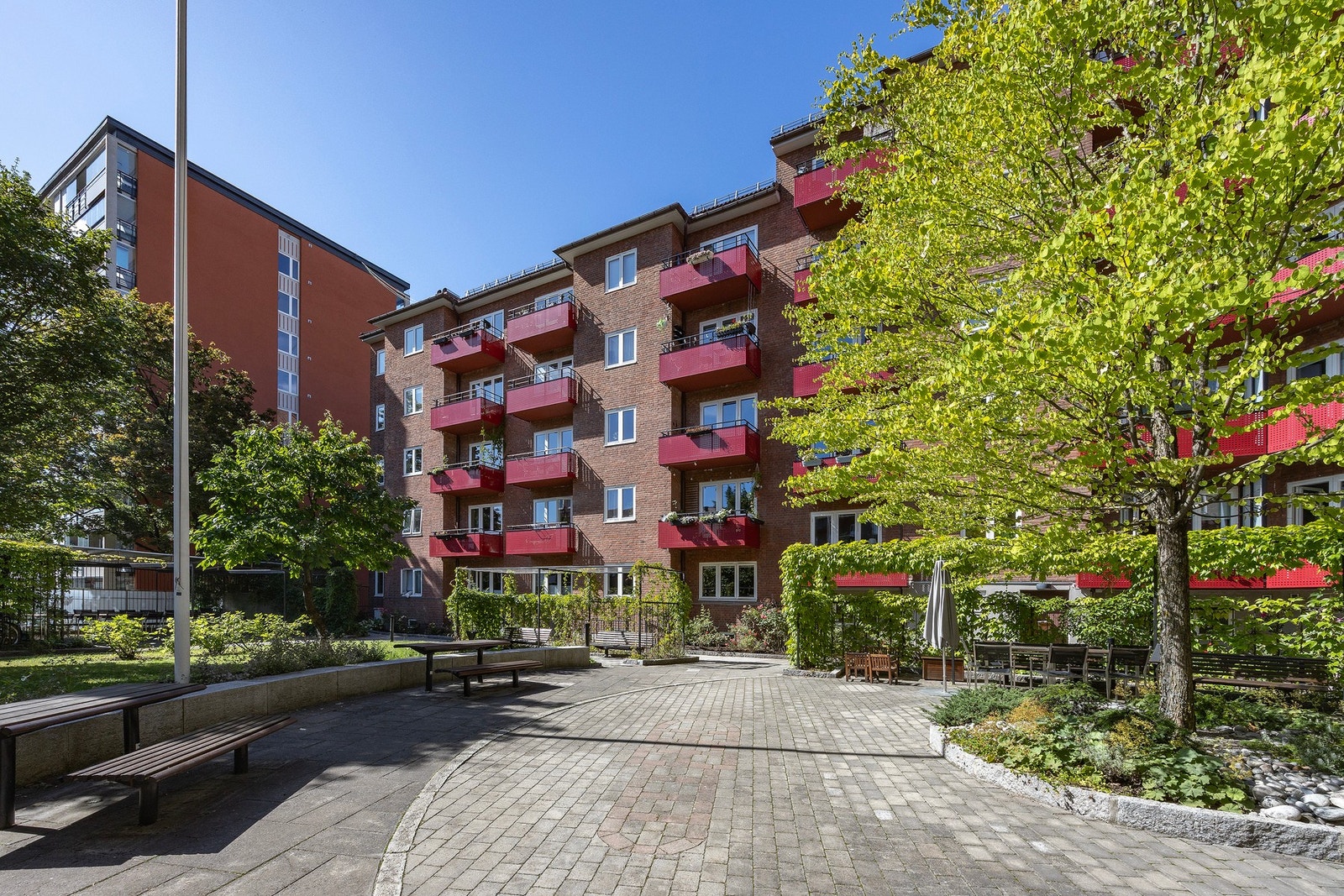 Gårdsrommet har ulike soner med sittebenker, langbord og sykkelparkering. Galleribilde