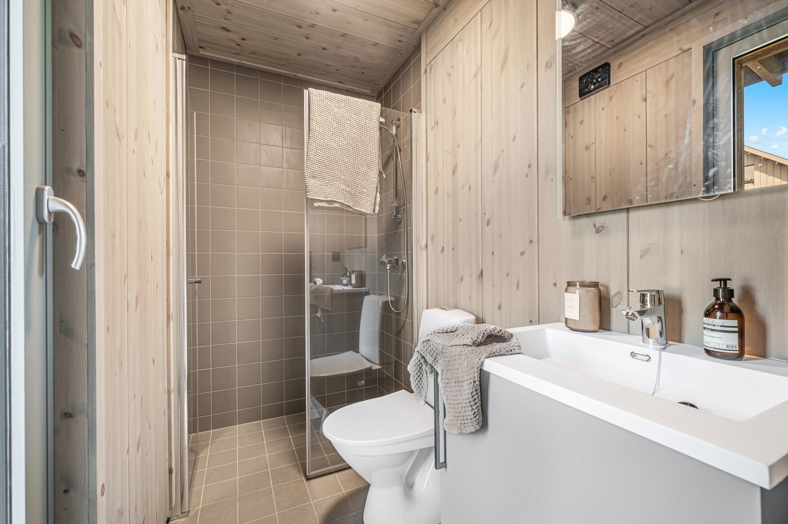 Delikat bad med wc, servant i innredning og en romslig dusjnisje med glassvegger. Galleribilde