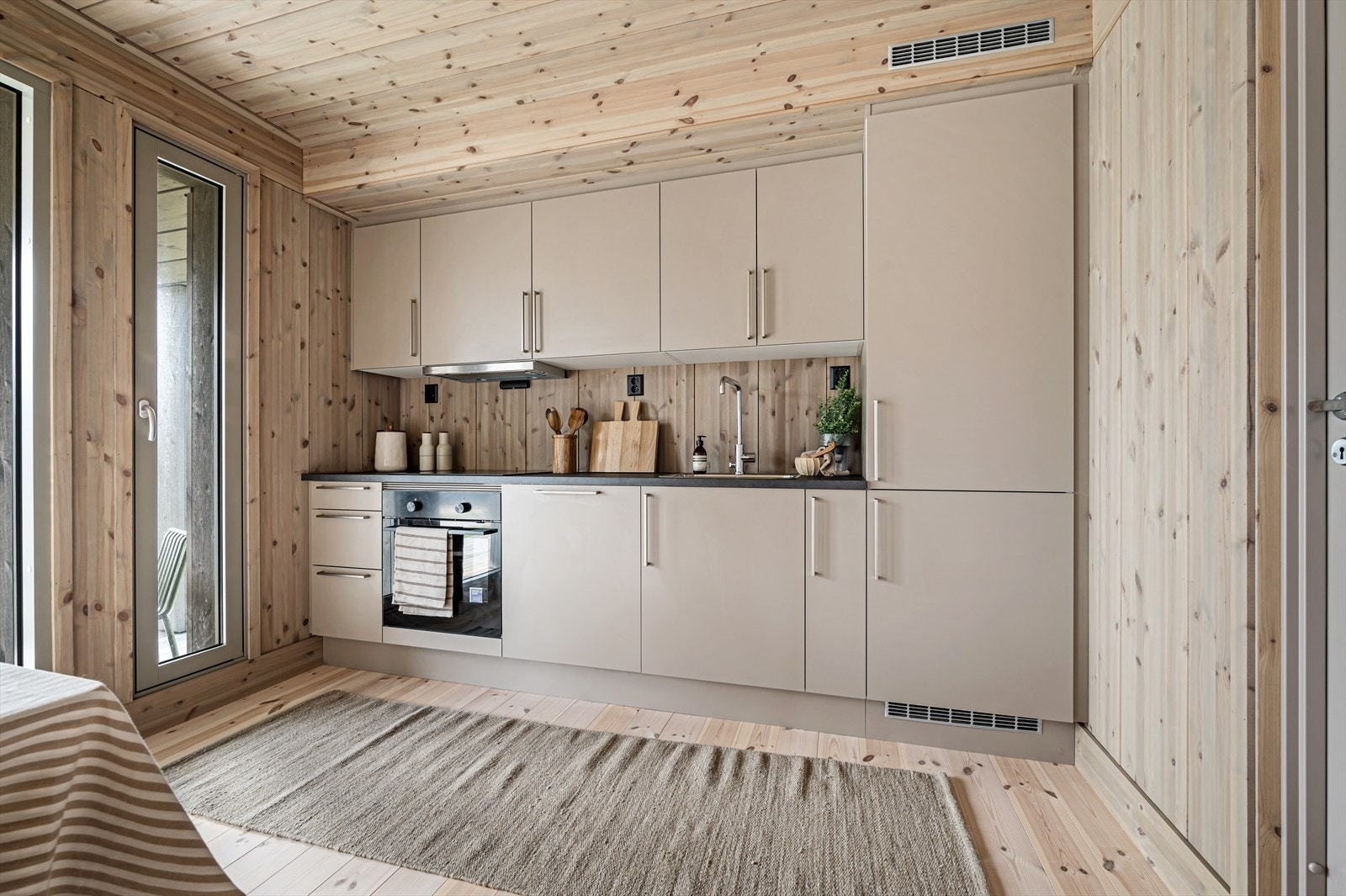 Kjøkken fra HTH med slette fronter. Komplett utstyrt med hvitevarer som er integrerte. Galleribilde