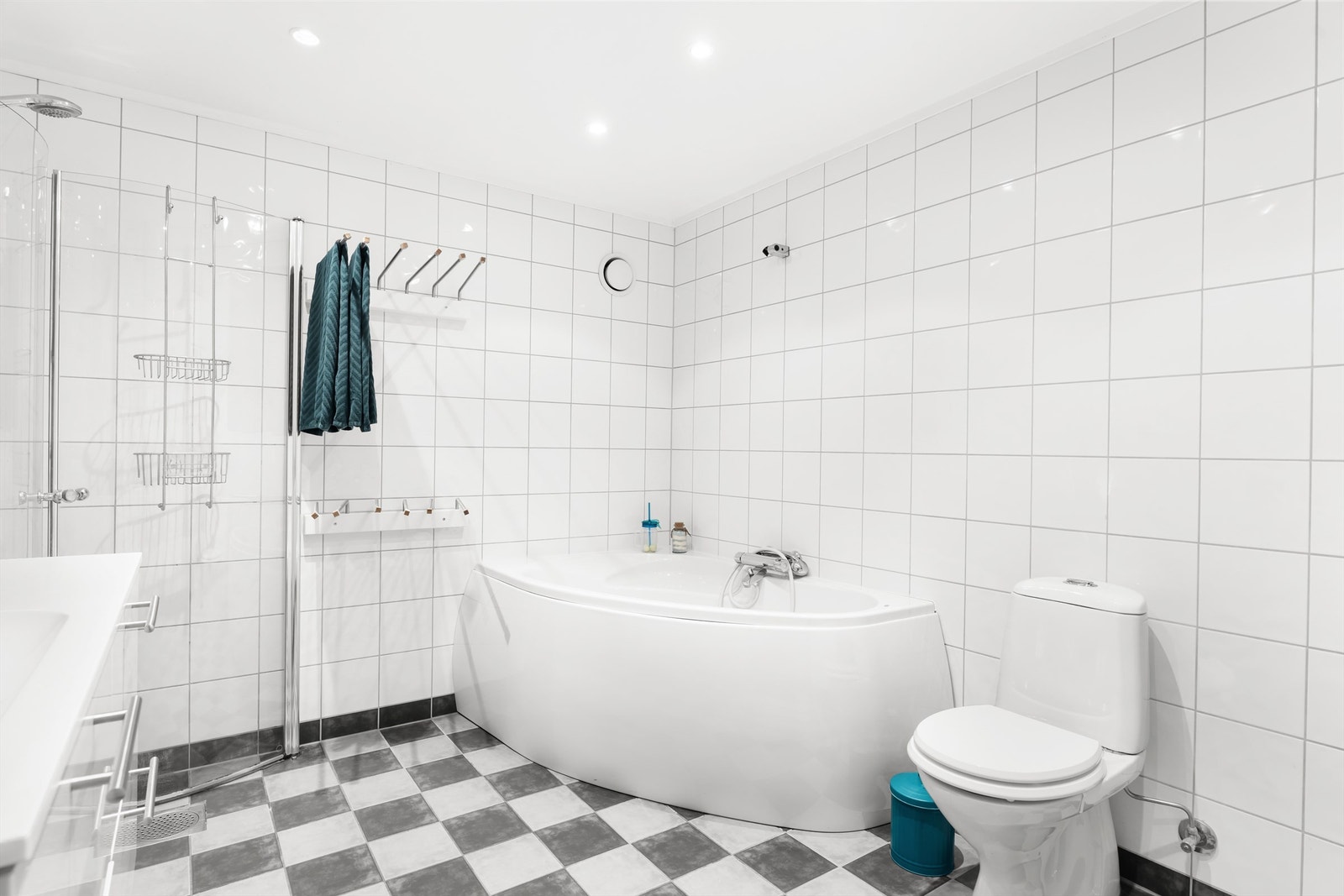 Baderommet har overskap med speildører, overlys, stikkontakt over servant, dusjnisje med buede glassdører og ett-greps armatur, samt badekar med ett-greps armatur. Galleribilde