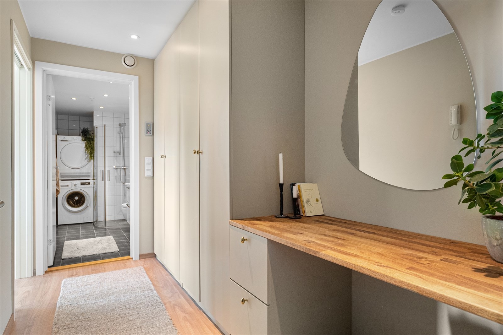 Lys og innbydende entré med elegant garderobeløsning som byr på rikelig skapplass og praktisk benkeplass som medfølger handelen. Galleribilde