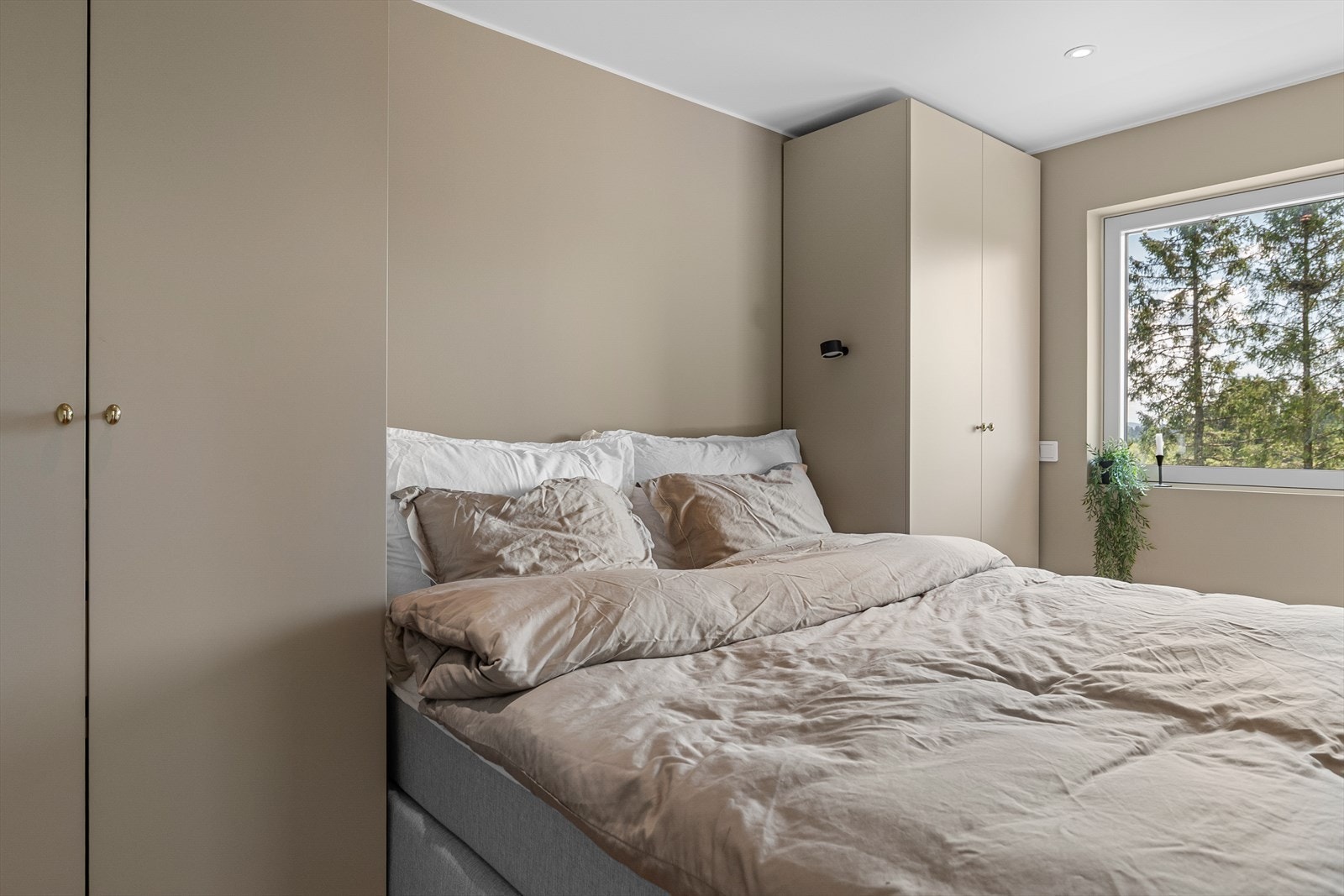 Leilighetens soverom er av god størrelse og her våkner man til roen av frodig utsikt. Galleribilde