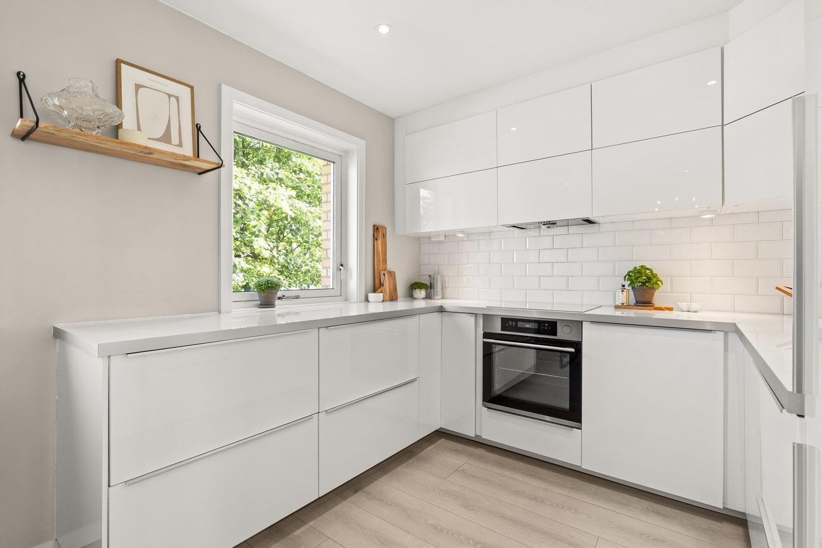 Kjøkkenet har integrerte hvitevarer som kjøl/fryseskap, oppvaskmaskin, platetopp, mikrobølgeovn og stekeovn Galleribilde