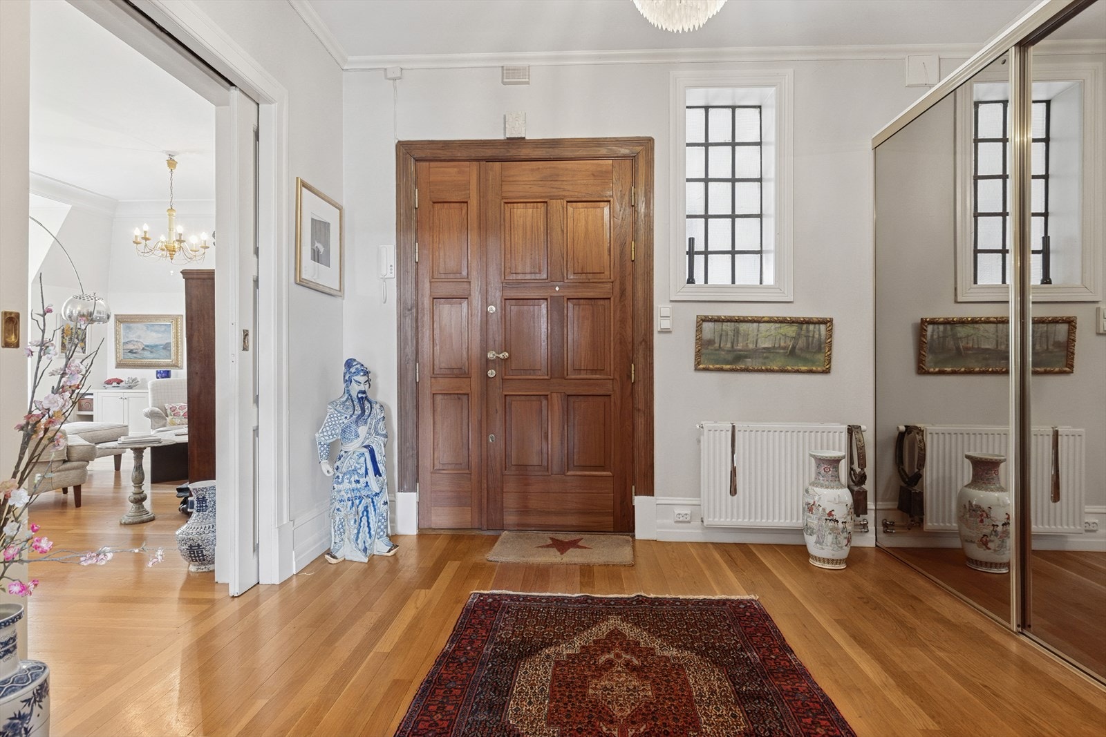 Den romslige hallen ønsker deg velkommen hjem med god takhøyde og en innbydende atmosfære. En praktisk skyvedørsgarderobe med god oppbevaringsplass sørger for en ryddig og funksjonell entré. Galleribilde