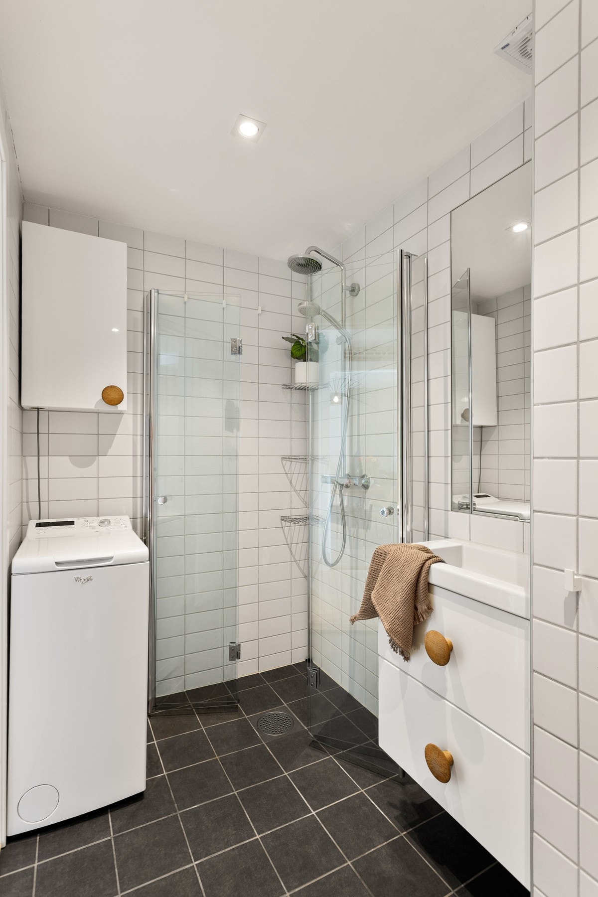 Badet er utstyrt med nedfelt servant, toalett og dusjvegger/hjørne. Galleribilde