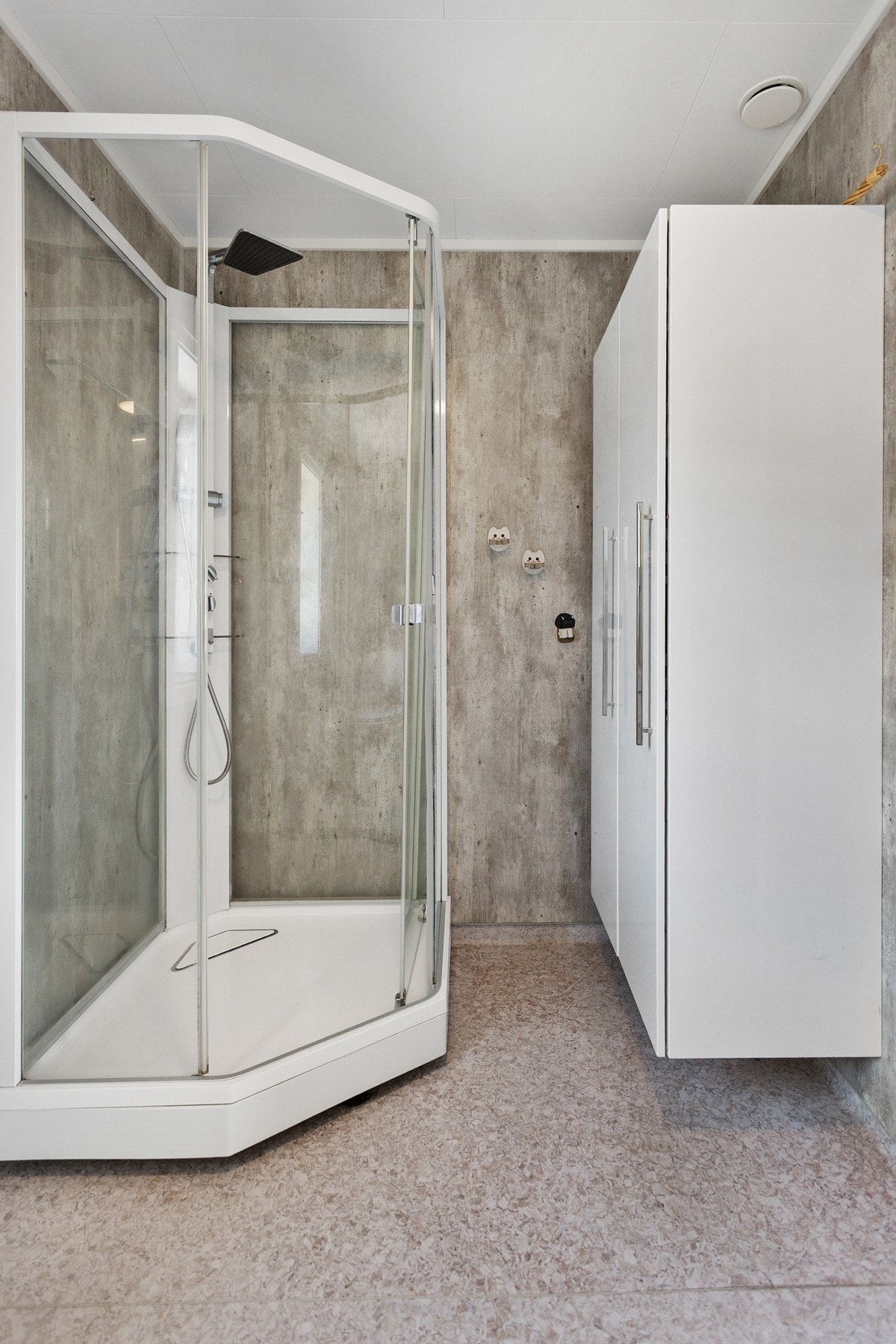 Badet er utstyrt med dusjkabinett, servantskap og toalett. Galleribilde