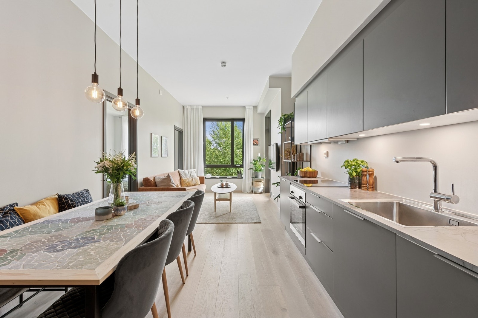 Med åpen løsning mot stuen blir kjøkkenet en sosial sone, også under matlagingen. Kjøkkenet er av moderne og smakfull karakter, i mørk utførelse. Galleribilde