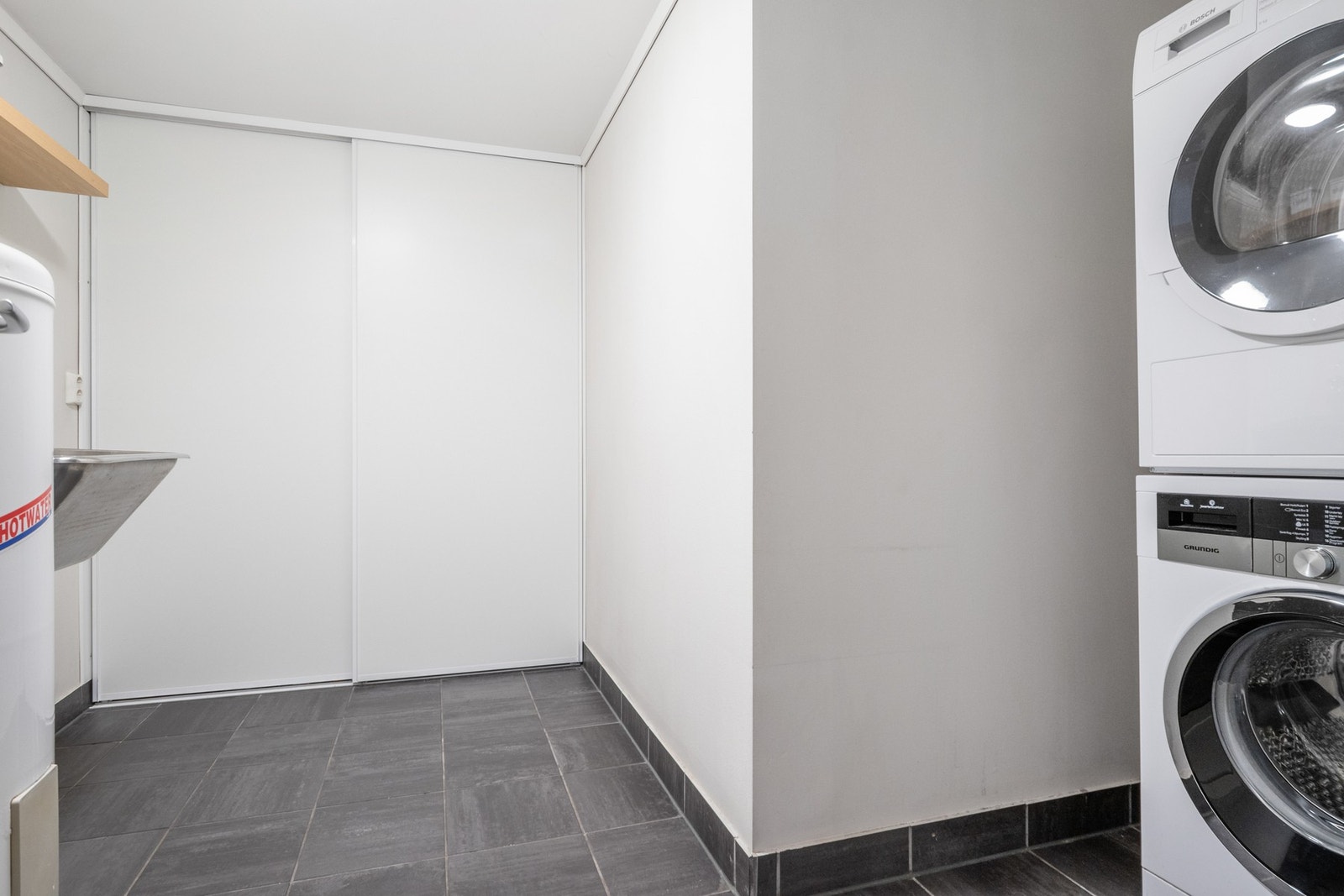 Vaskerommet er utstyrt med skyvedørsgarderobe, skyllekum og opplegg for vaskemaskin. Galleribilde