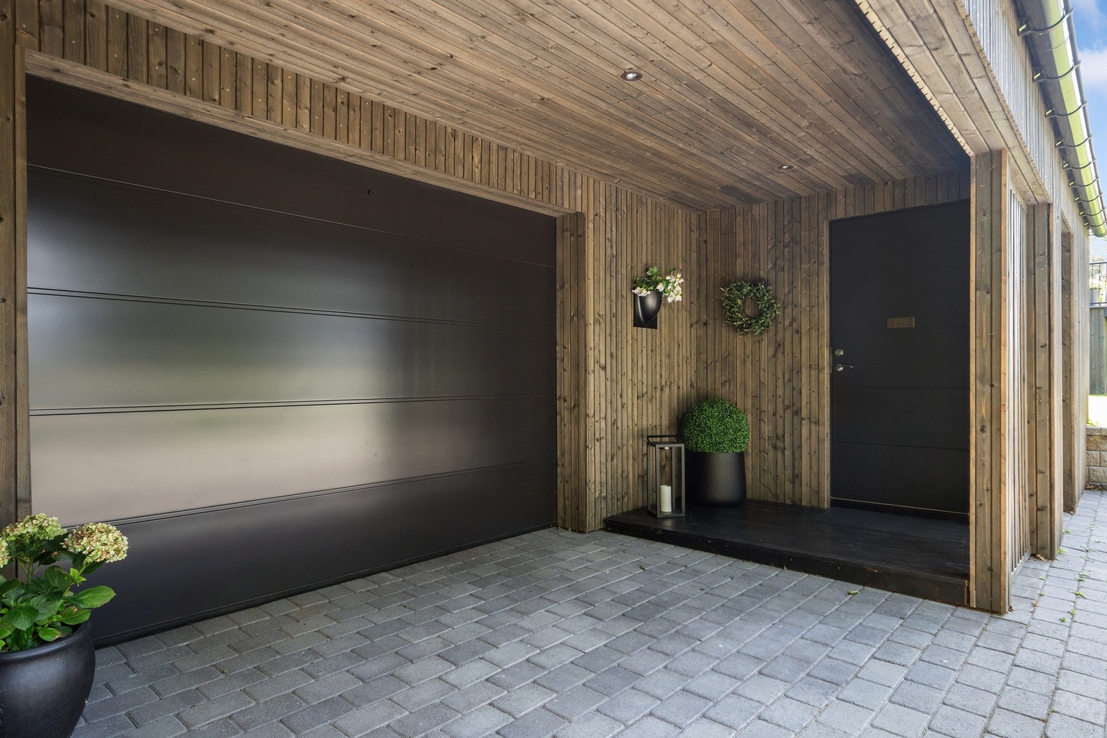 Boligen har et inntrukket og skjermet inngangsparti med steinbelagt adkomst, repos i tre og takmonterte downlights. Galleribilde