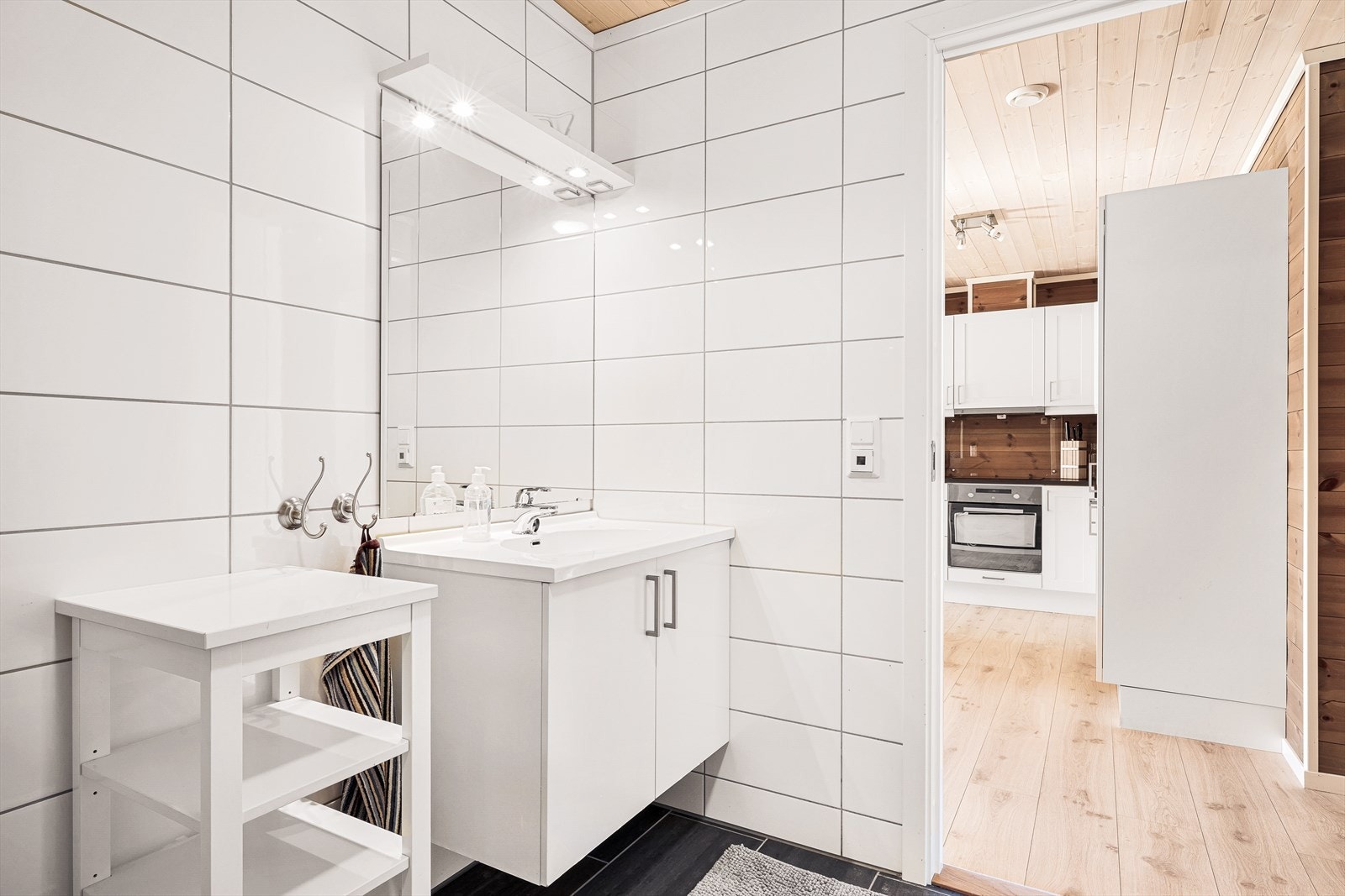 Badet er ellers innredet med toalett, dusjhjørne og servant med skapinnredning Galleribilde