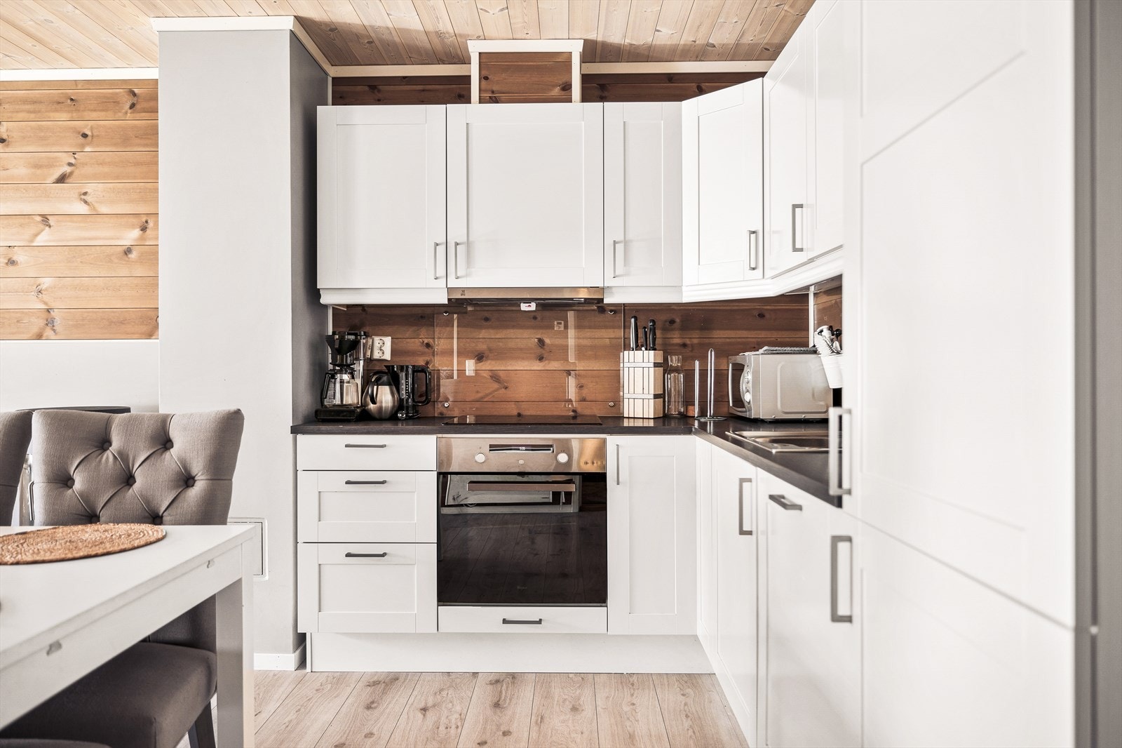 Stilren glassplate på vegg ved platetopp og vask gir både en moderne følelse og praktisk beskyttelse Galleribilde