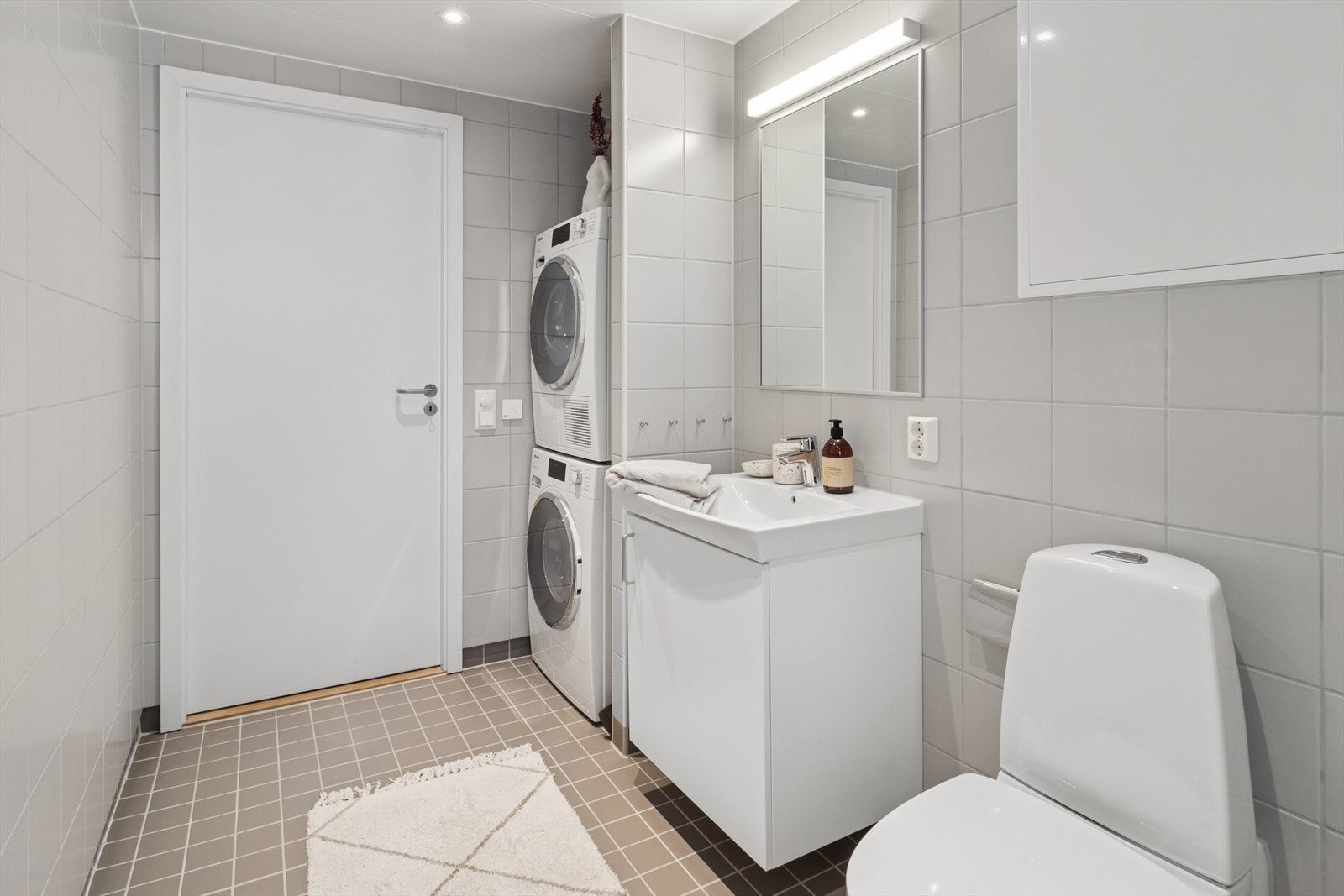 Hovedbadet er innredet med baderomsinnredning med underskap ,dusjhjørnet med innfellbare glassdører, veggmontert toalett og opplegg for vaskemaskin. Galleribilde