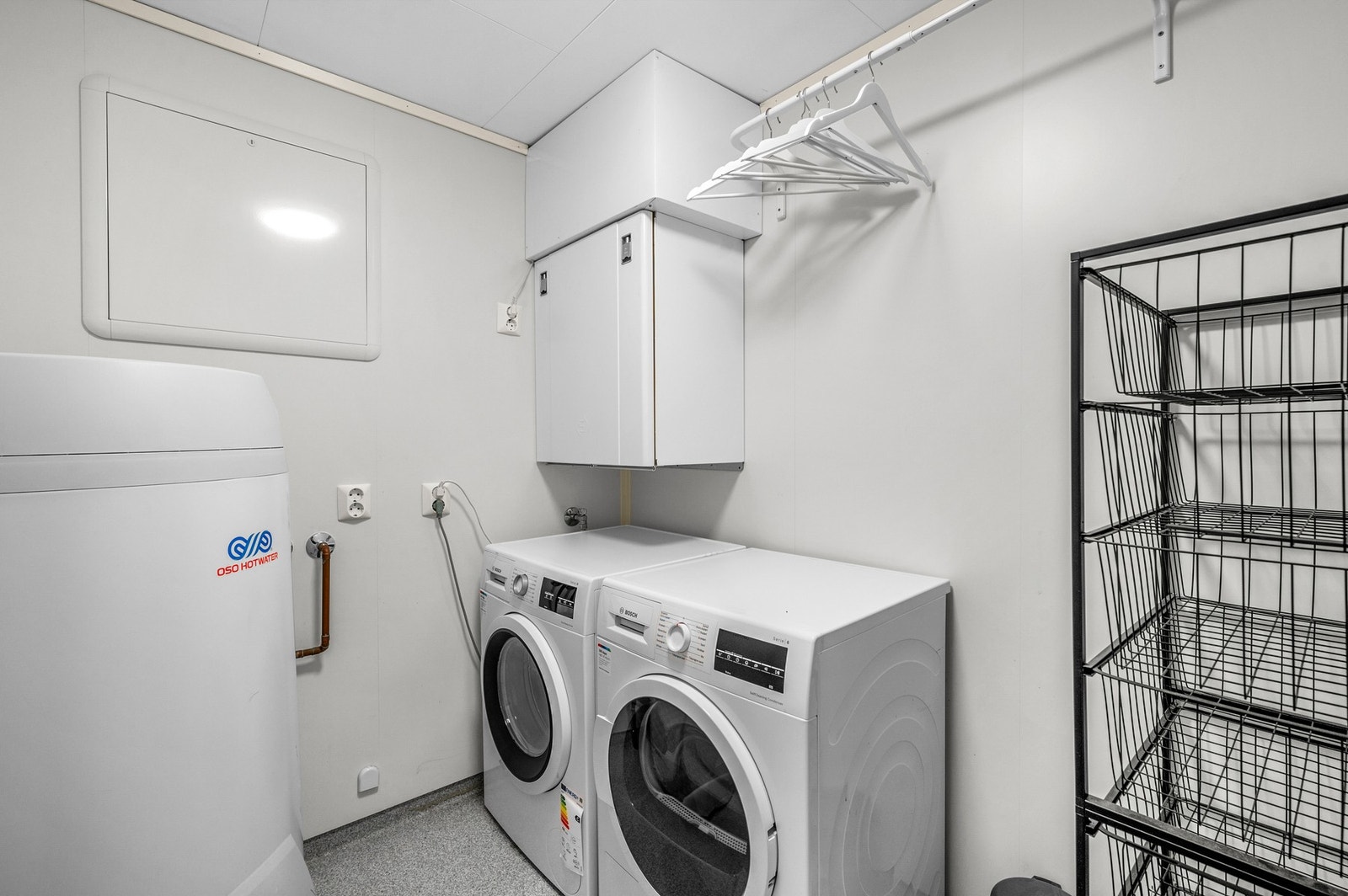 Separat vaskerom på 4 kvm med praktisk tørkestativ på vegg og hyllesystem Galleribilde