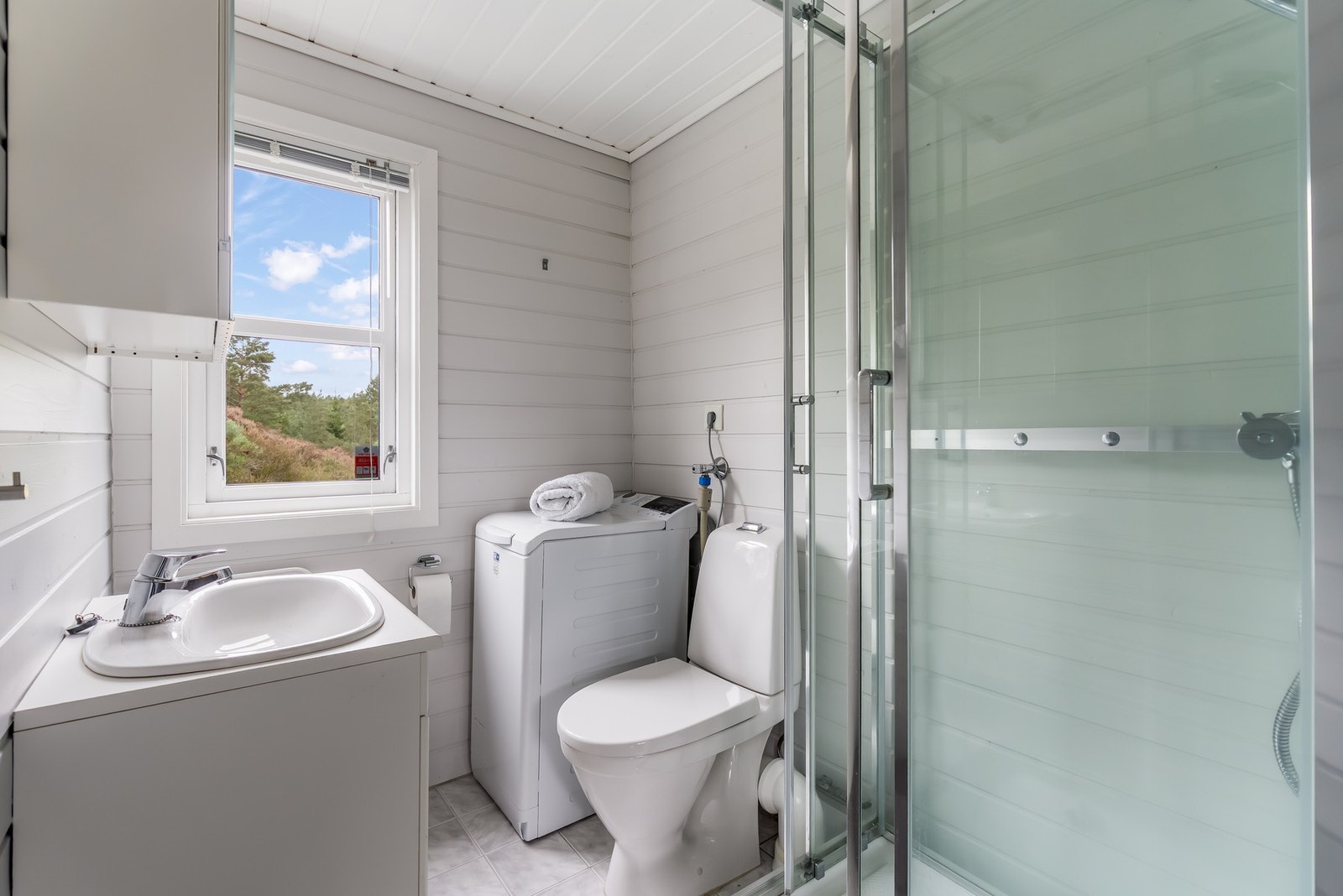 Vaskerommet er kombinert med badet og har opplegg for vaskemaskin. Rommet har gulv med fliser og vegger med panel. Galleribilde