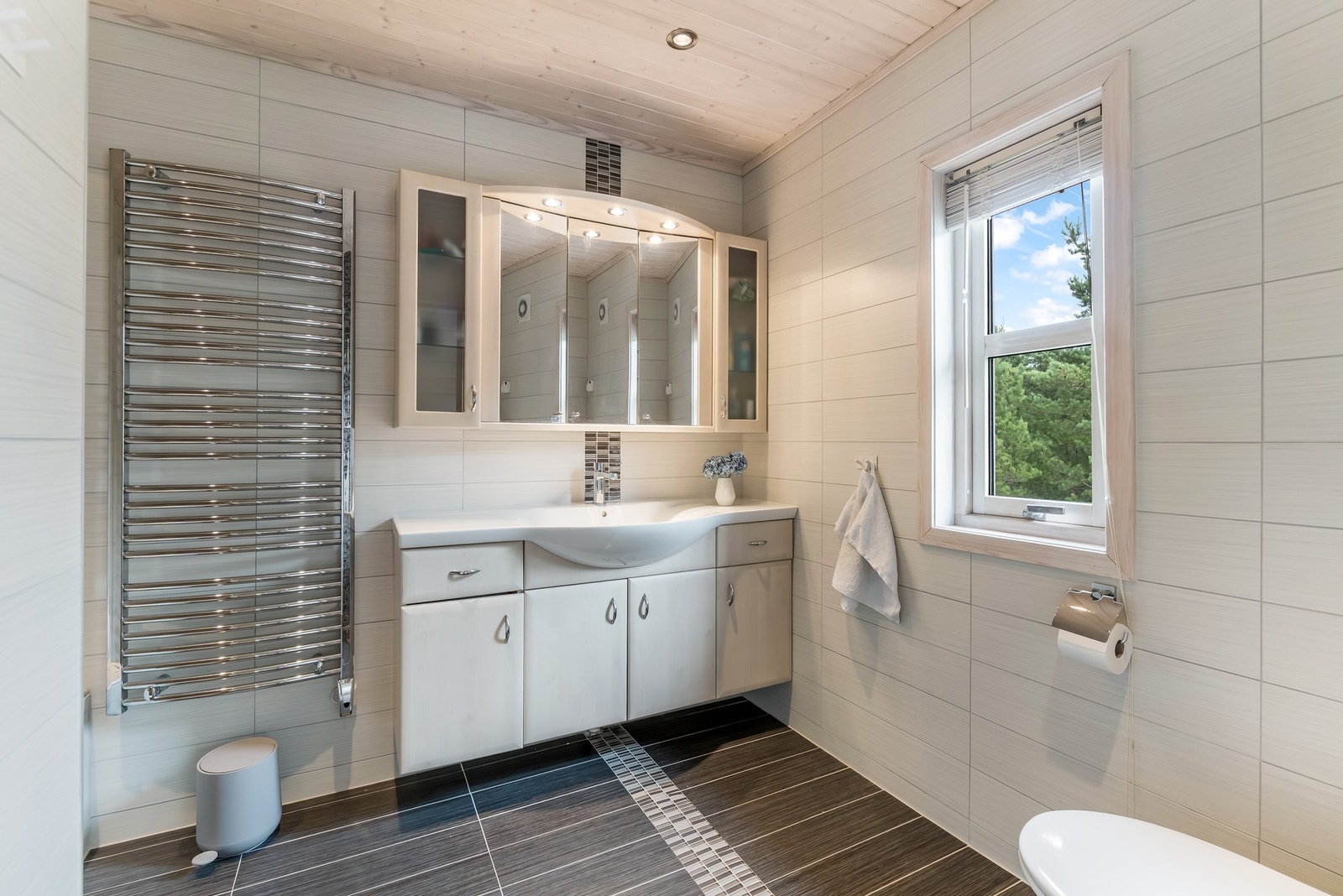 Badet har flislagt gulv og vegger med fliser, kombinert med panel i taket. Galleribilde