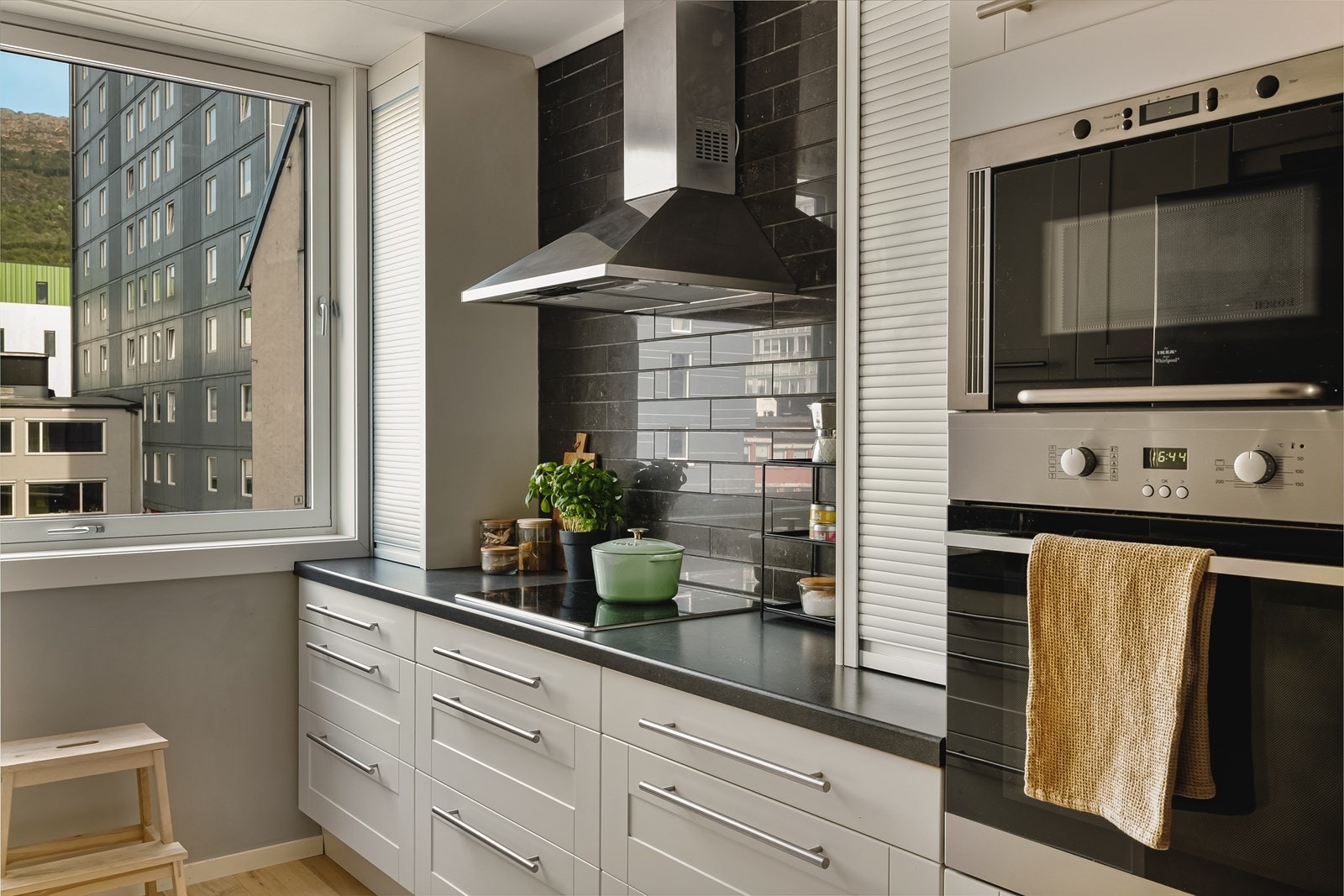 God plass til oppbevaring i takhøy innredning, og det er keramiske fliser over benkeplaten som gjør det enkelt å holde rent. Galleribilde